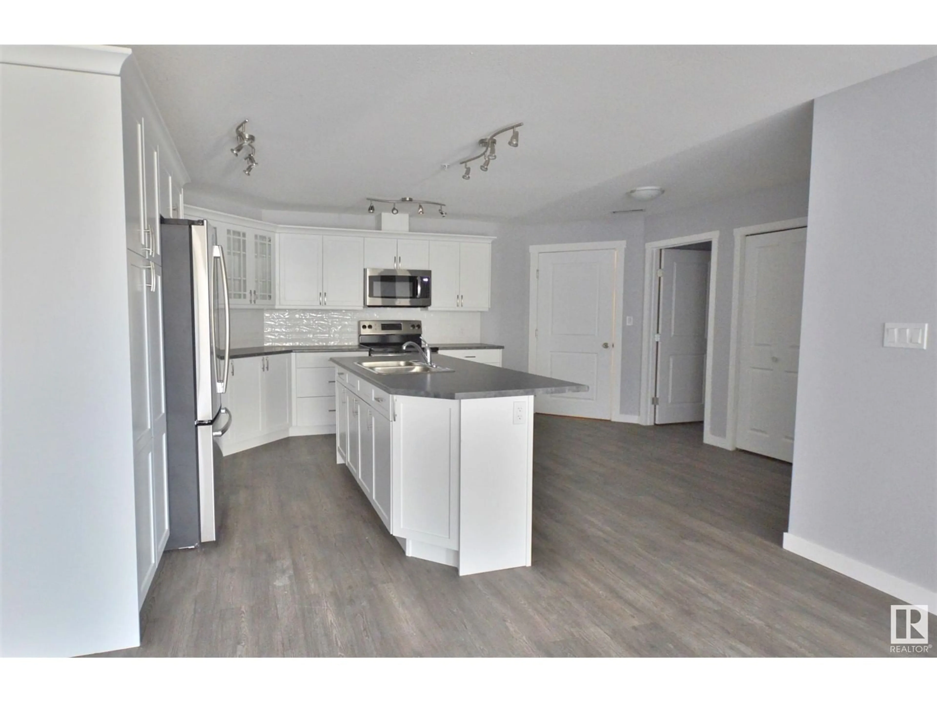 Open concept kitchen, wood/laminate floor for 202 - 4110 43 AV, Bonnyville Town Alberta T9N1S8