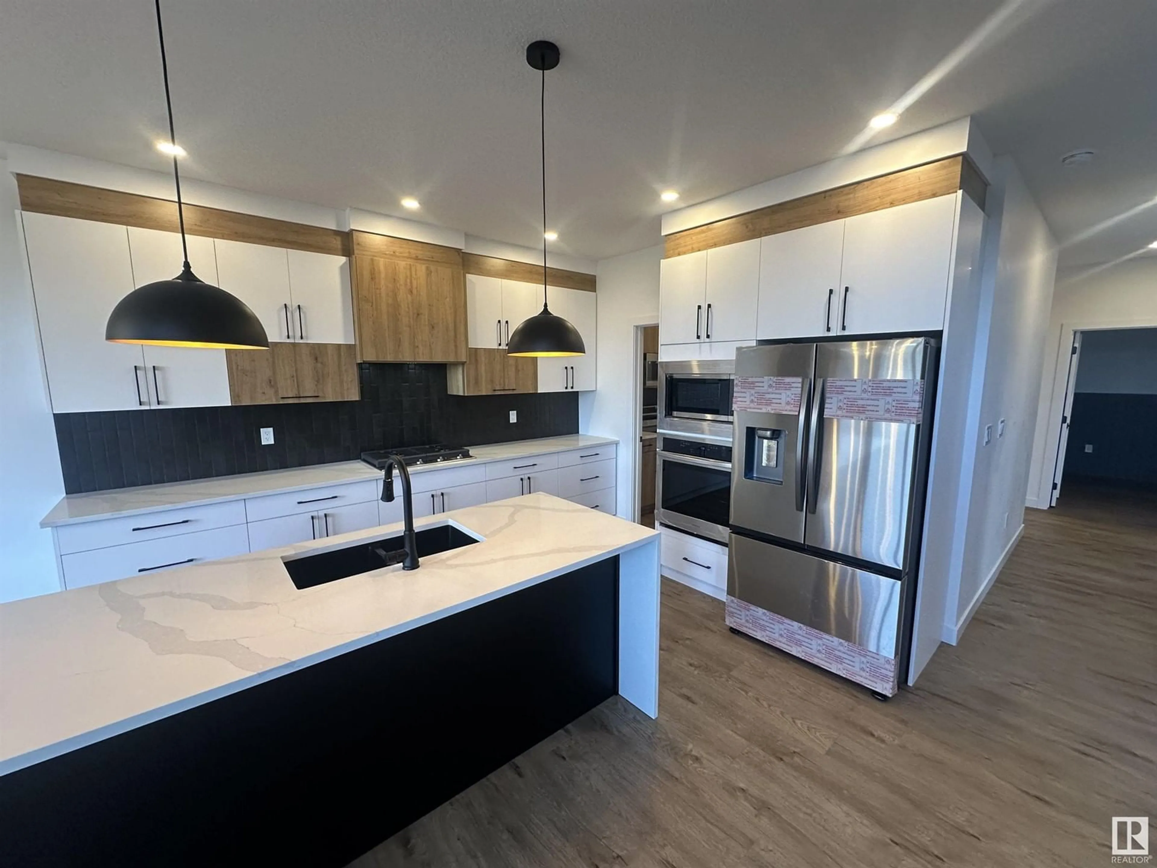 Open concept kitchen, wood/laminate floor for 205 KETTYL CO, Leduc Alberta T9E1S1