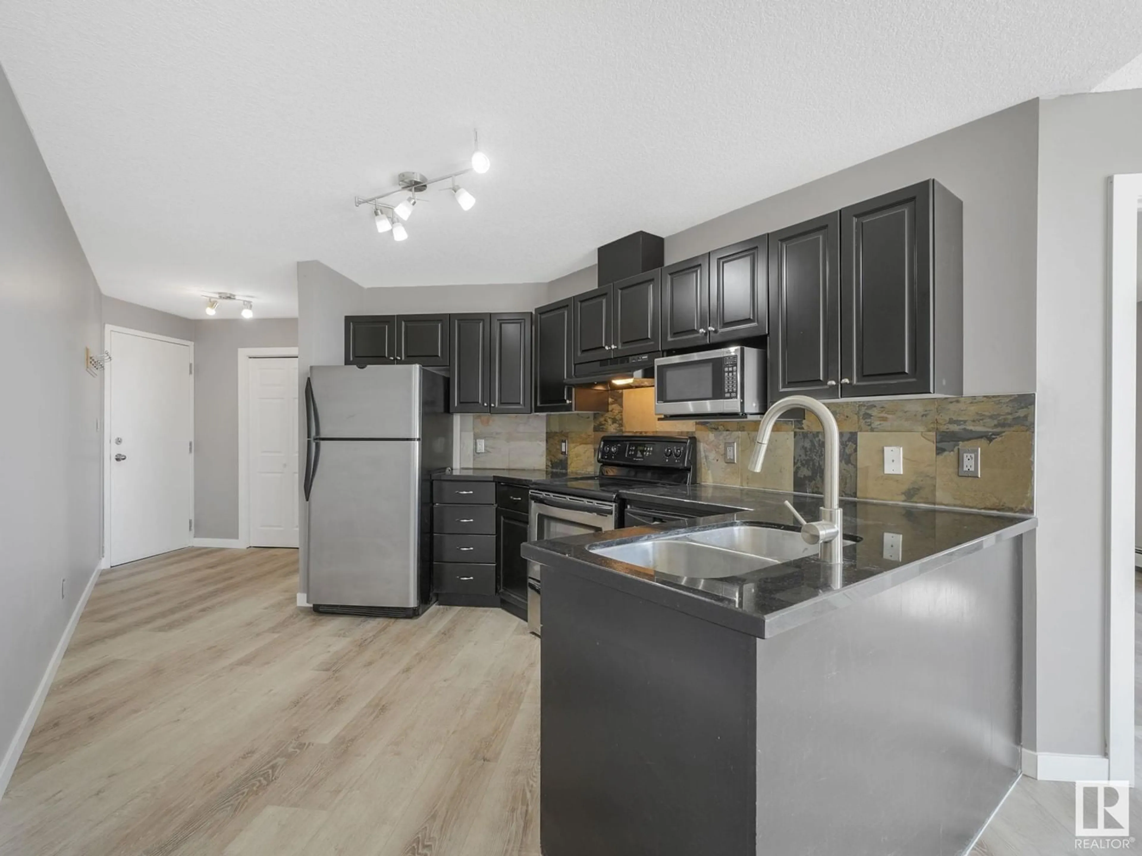 Open concept kitchen, wood/laminate floor for #303 - 9336 JASPER AV, Edmonton Alberta T5H3T5