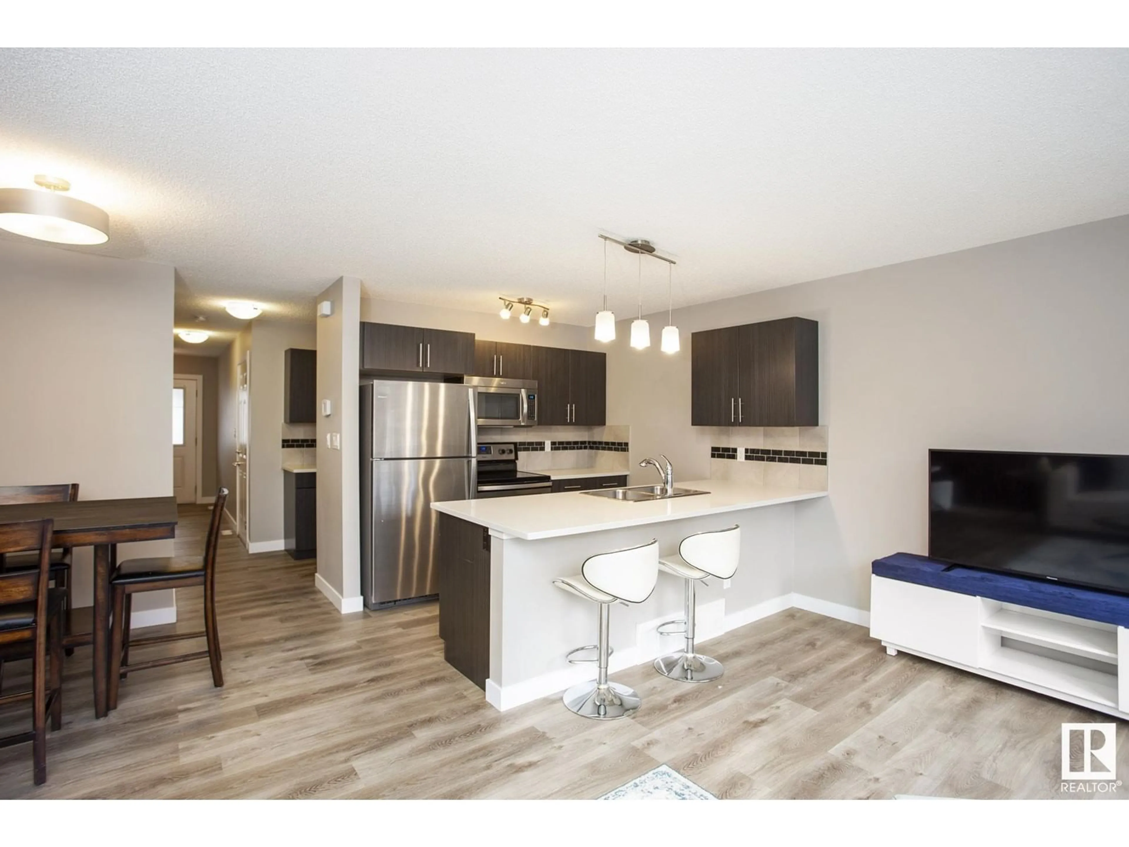 Open concept kitchen, wood/laminate floor for 2004 - 30 TRUMPETER WY, Edmonton Alberta T5S0J9