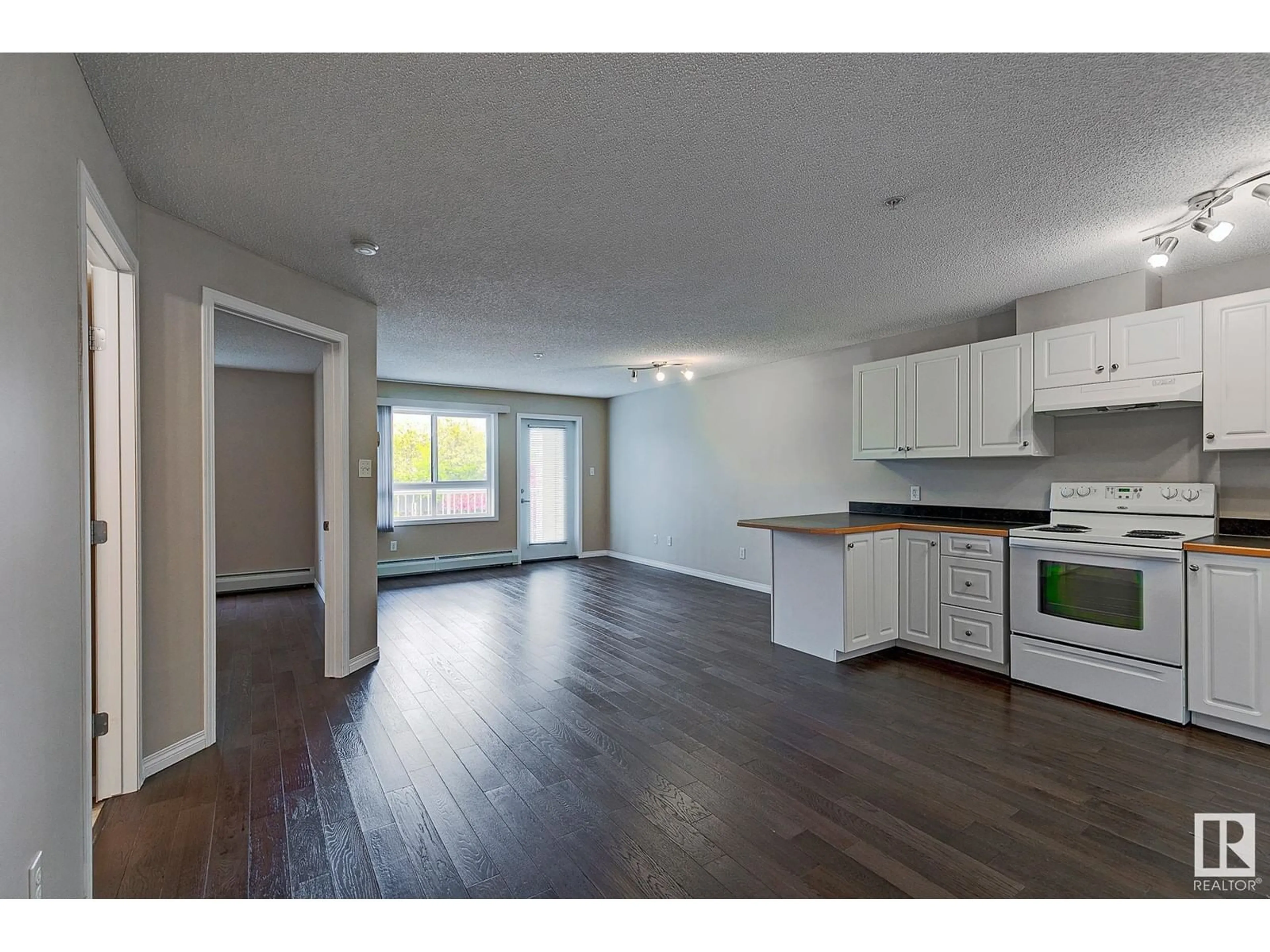 Open concept kitchen, wood/laminate floor for #212 - 5350 199 ST, Edmonton Alberta T6M0A4