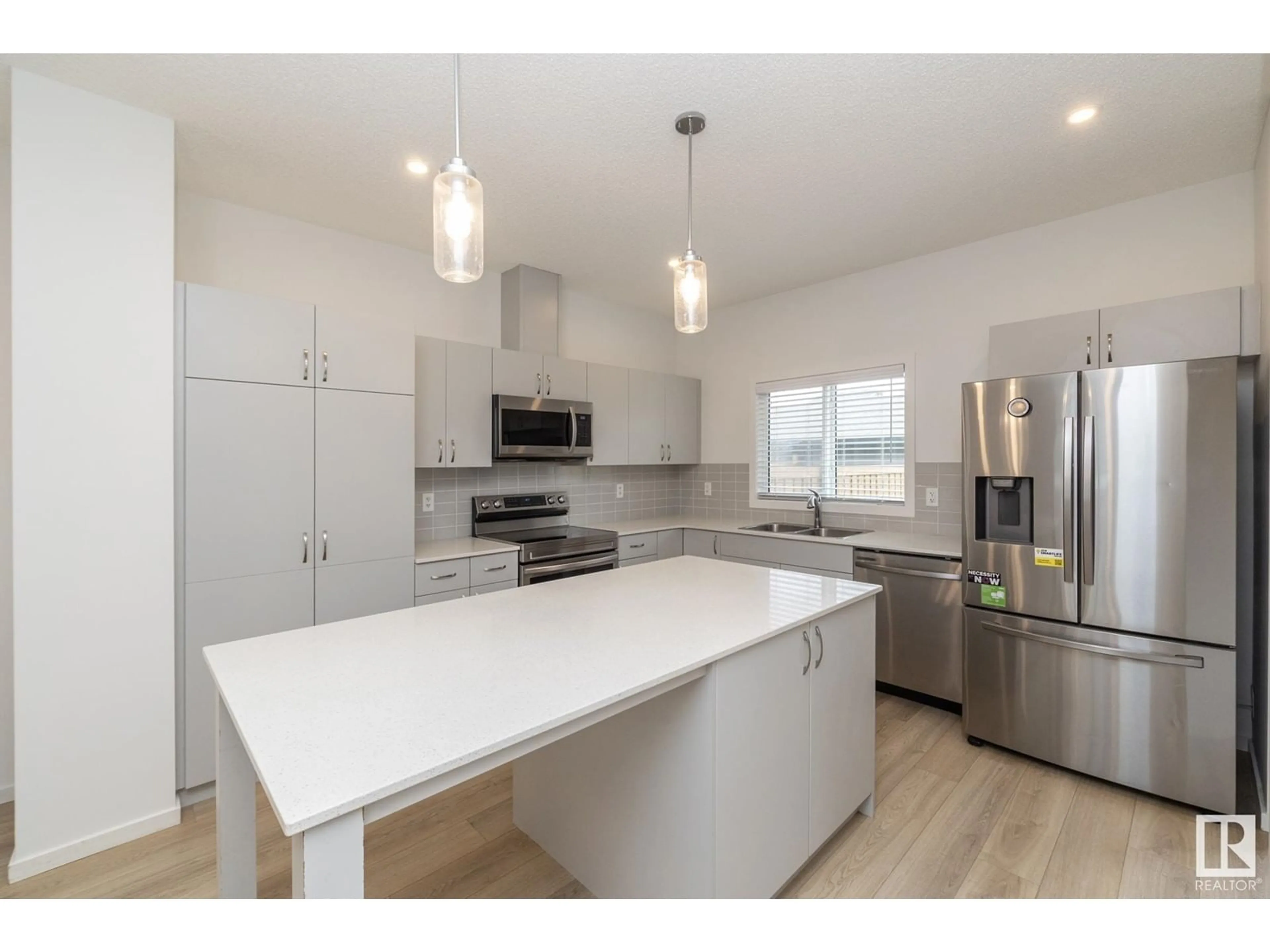 Open concept kitchen, wood/laminate floor for 1279 ROSENTHAL BV, Edmonton Alberta T5T7N7