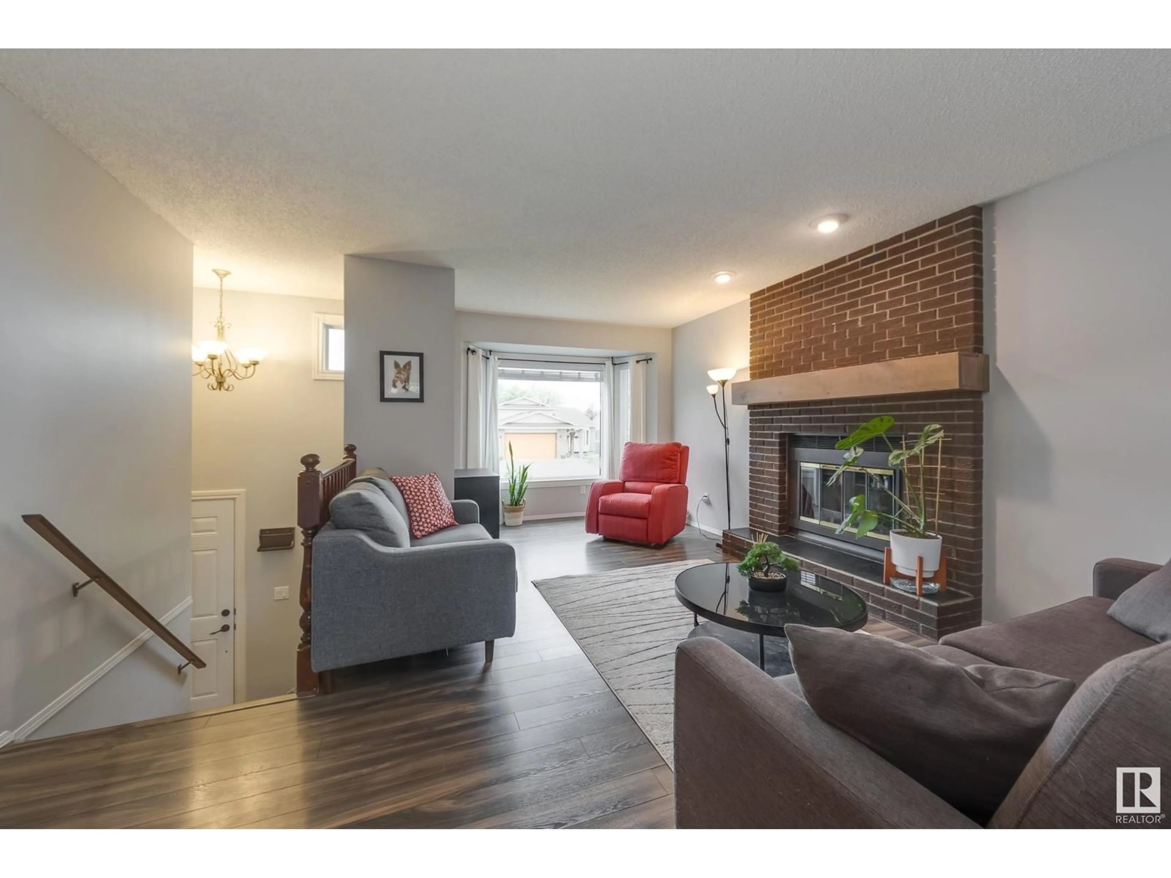 Living room with furniture, wood/laminate floor for NW - 7004 152C AV, Edmonton Alberta T5C3P4