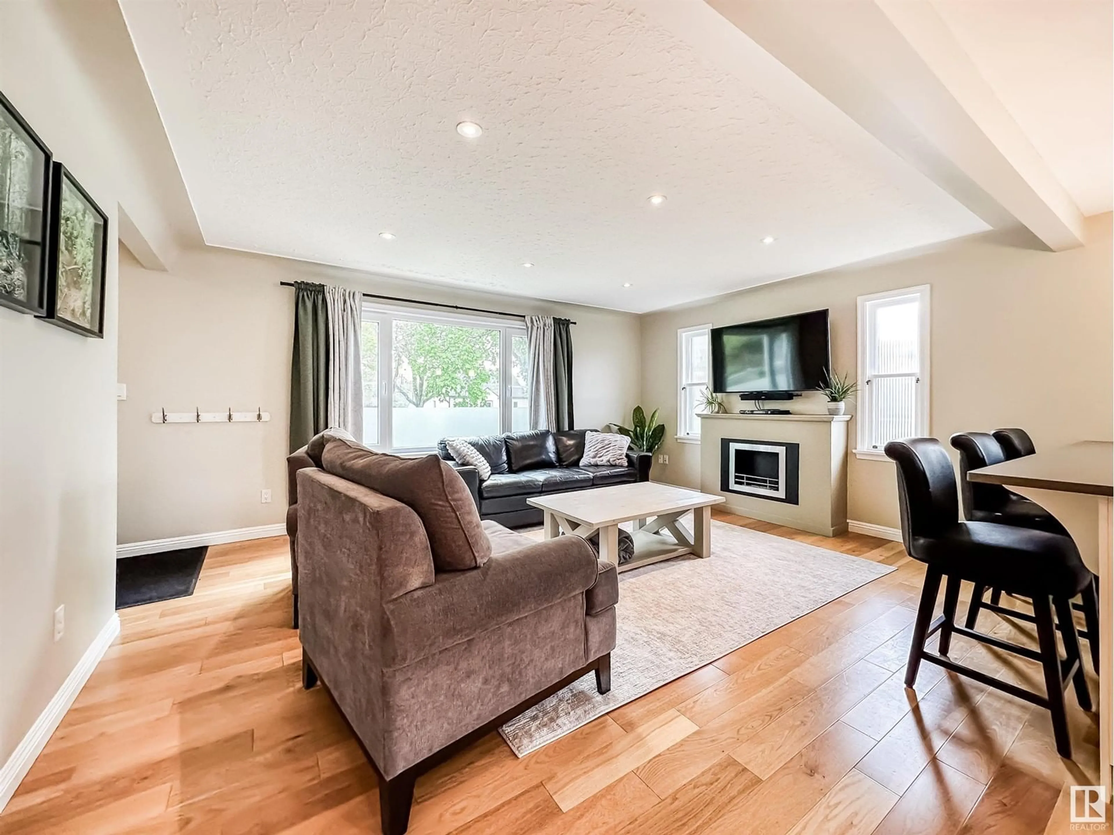 Living room with furniture, wood/laminate floor for NW - 10978 135 ST, Edmonton Alberta T5M1K2