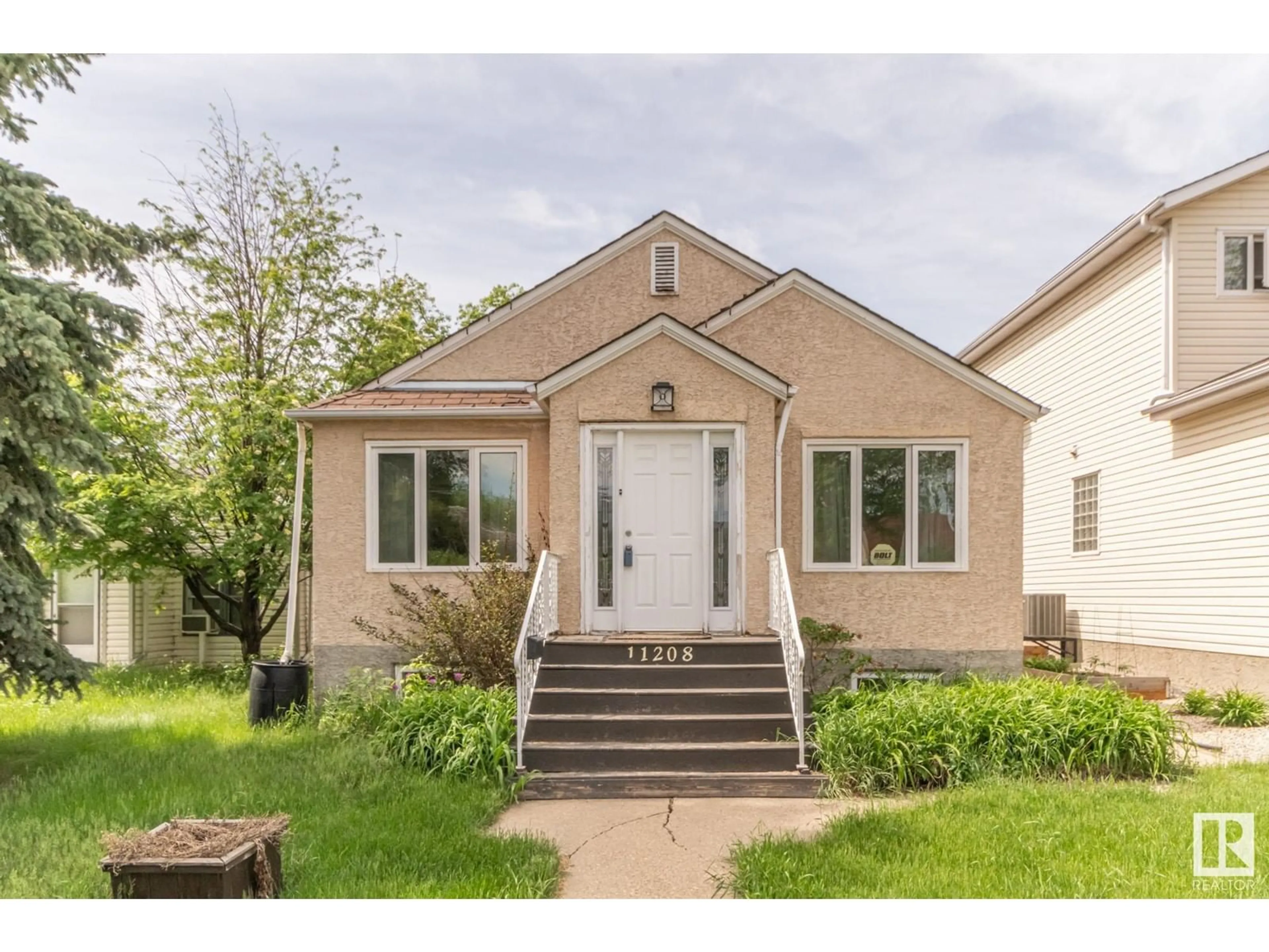 Home with vinyl exterior material, street for NW - 11209 79 ST, Edmonton Alberta T5B2J7
