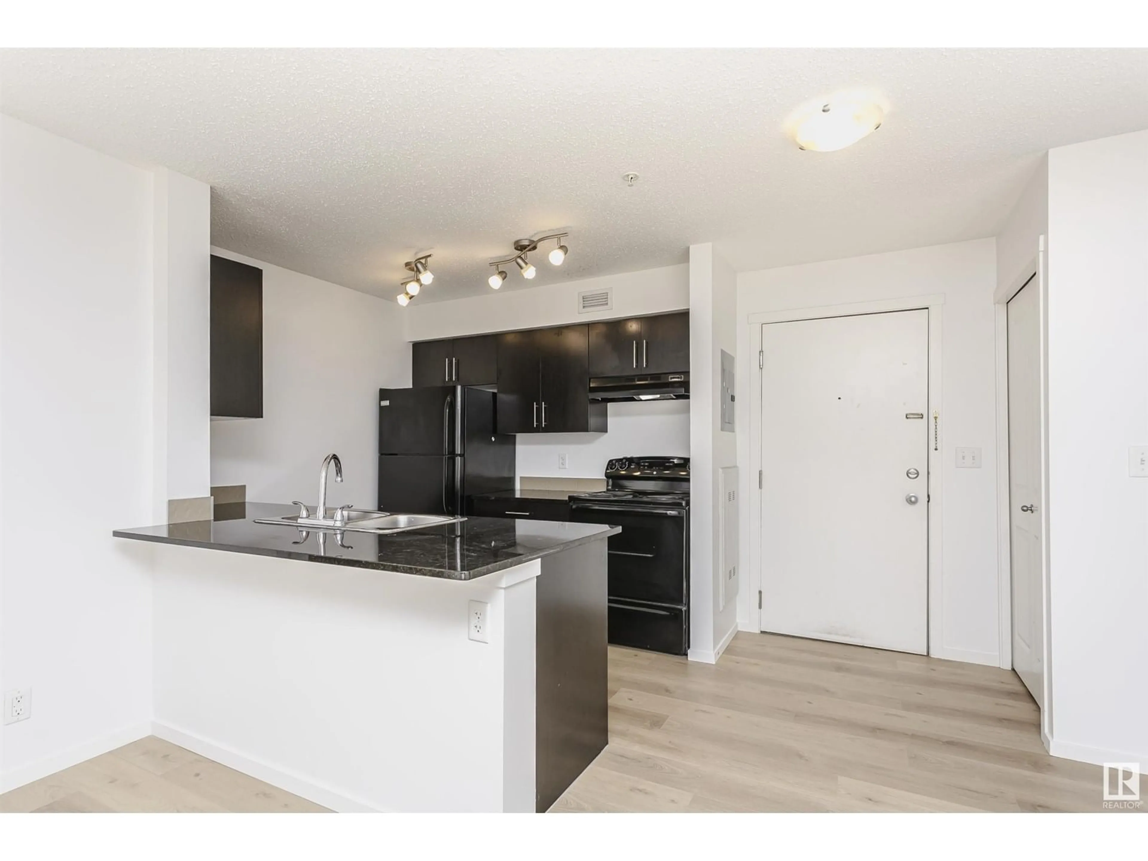 Open concept kitchen, wood/laminate floor for #223 - 5816 MULLEN PL, Edmonton Alberta T6R0W3