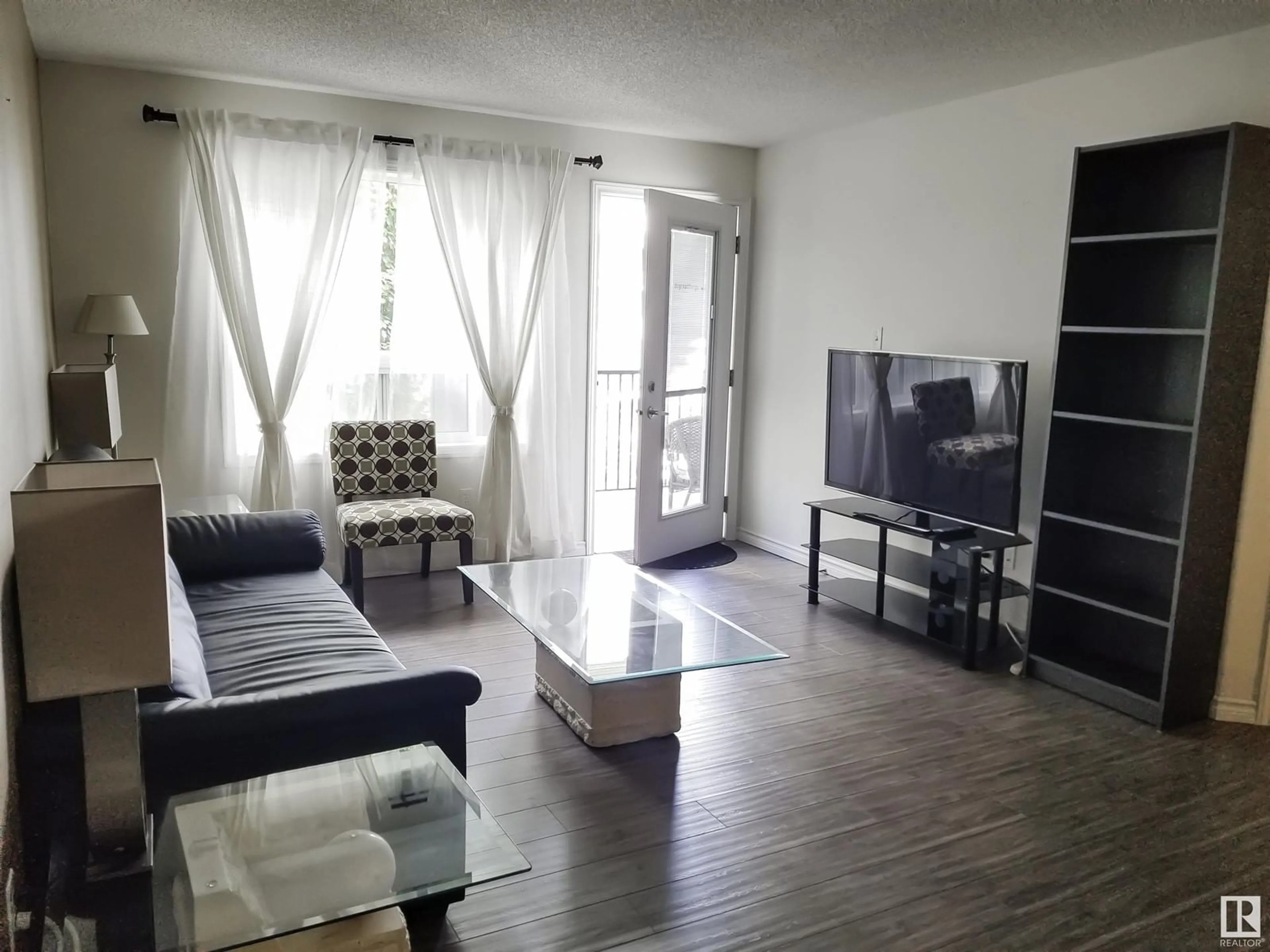 Living room with furniture, wood/laminate floor for 9363 NW - 1332 SIMPSON DR, Edmonton Alberta T6R0N2