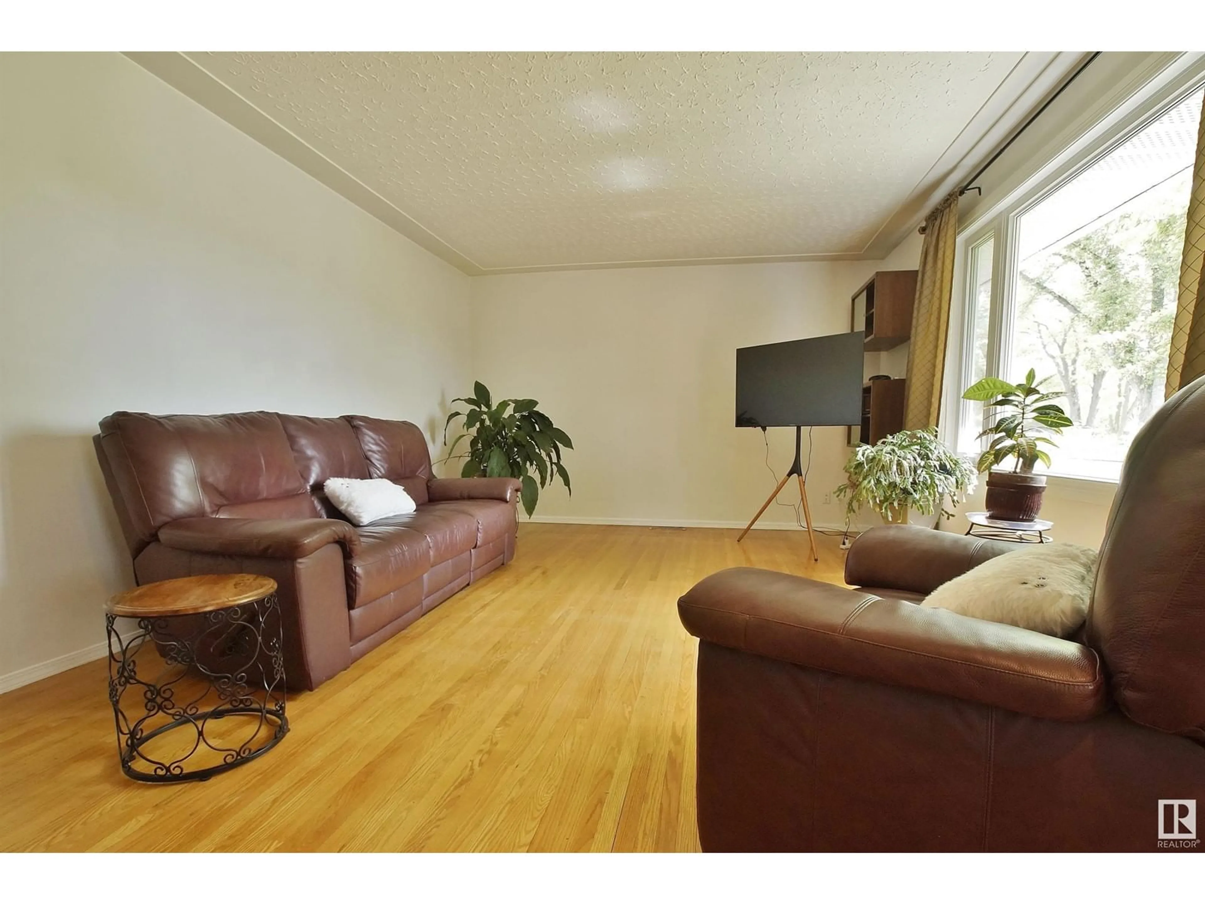 Living room with furniture, wood/laminate floor for 10520 130 AV, Edmonton Alberta T5E0S8