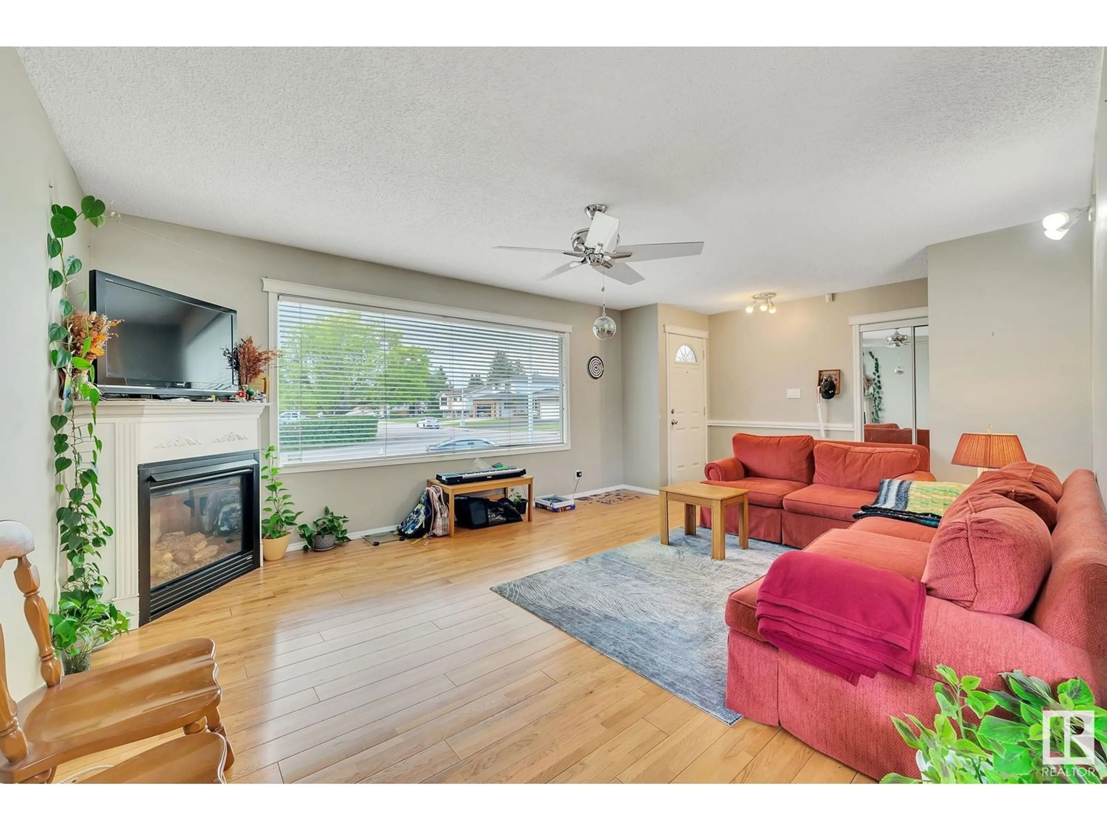 Living room with furniture, wood/laminate floor for 107 EKOTA CR, Edmonton Alberta T6K2J6