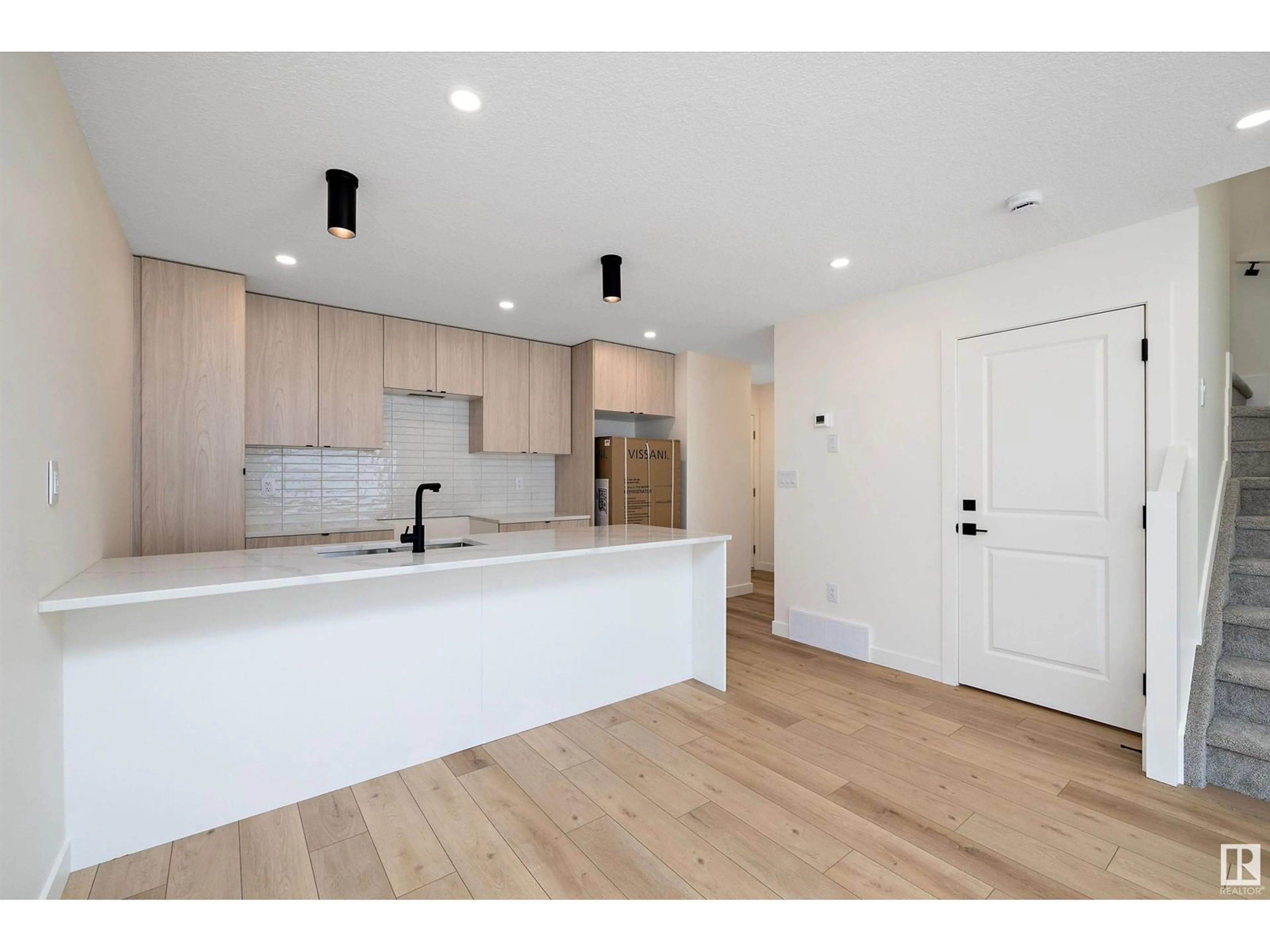 Open concept kitchen, wood/laminate floor for 11338 89 ST, Edmonton Alberta T5B3T6