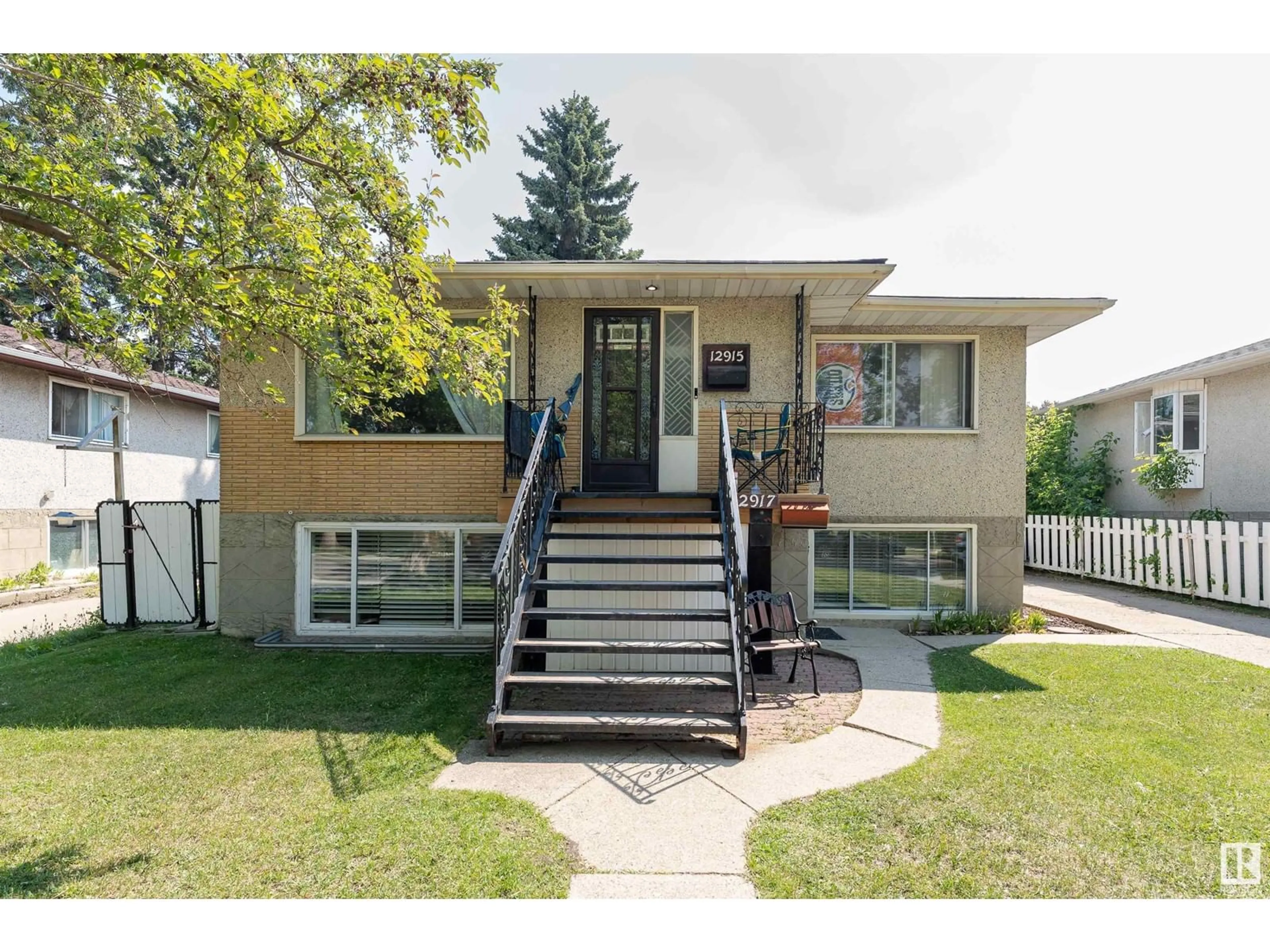 Home with vinyl exterior material, street for 12915/12917 102 ST NW, Edmonton Alberta T5C4J4
