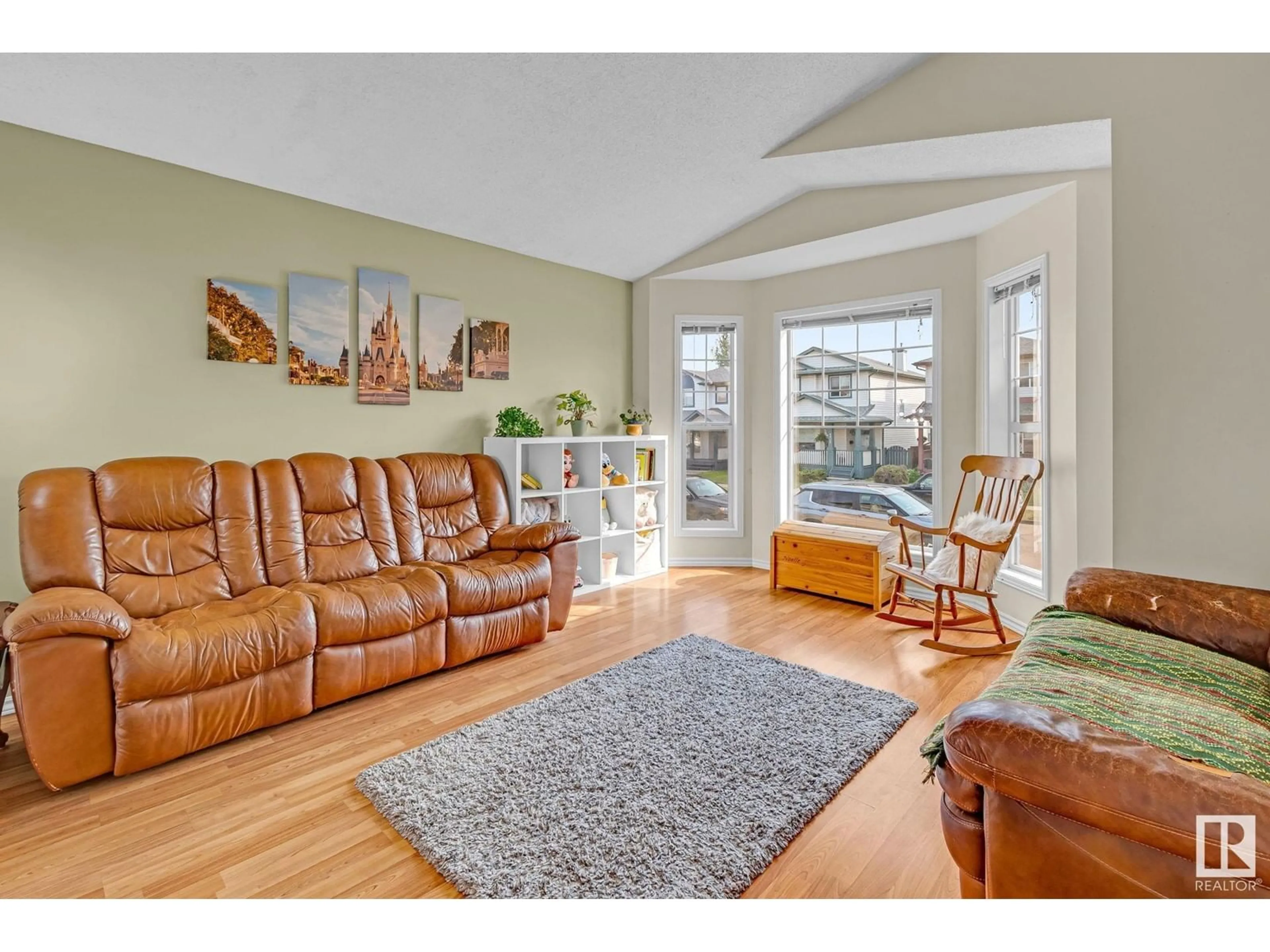 Living room with furniture, wood/laminate floor for NW - 4420 150 AV, Edmonton Alberta T5Y2Z9