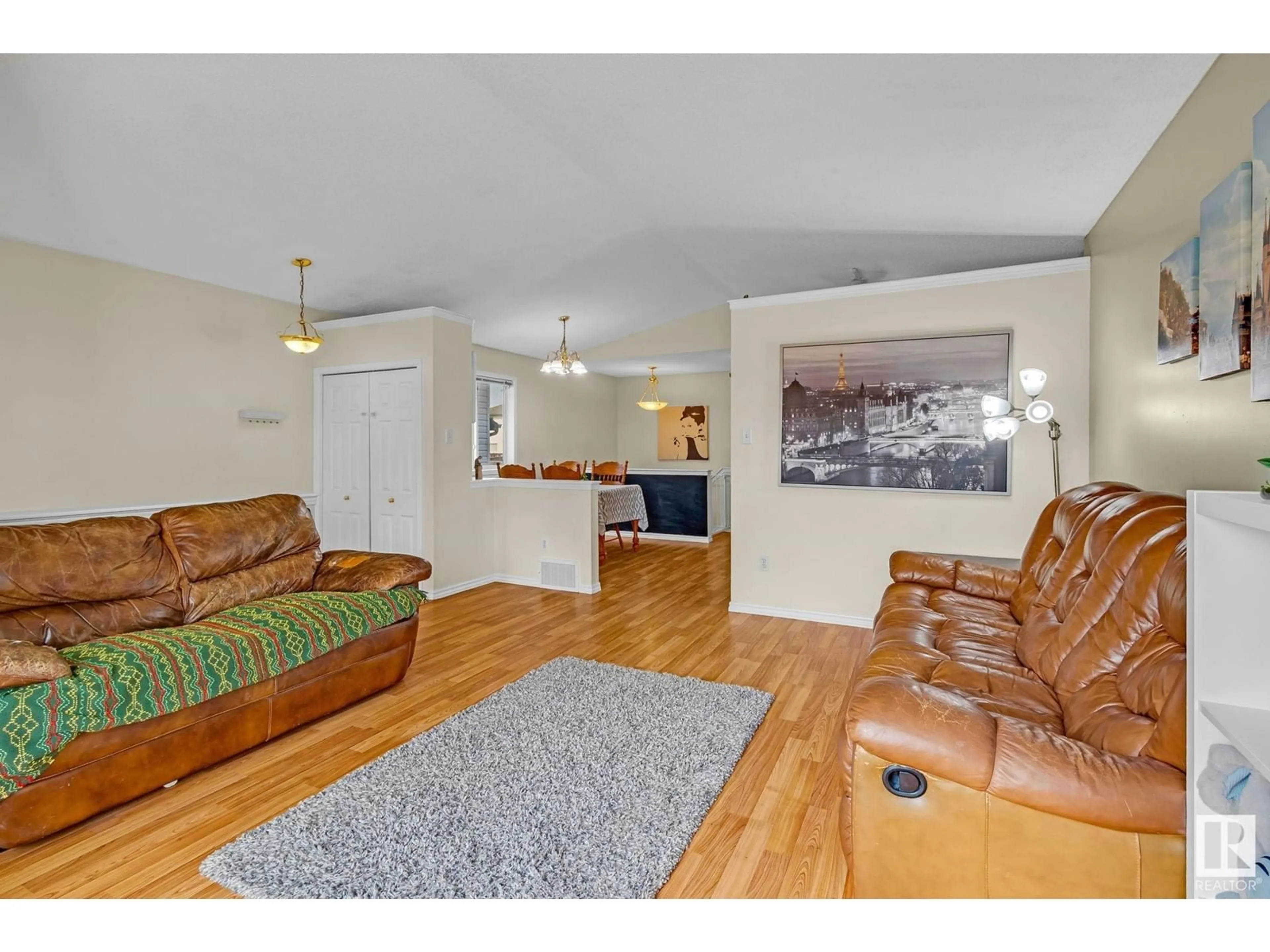 Living room with furniture, wood/laminate floor for NW - 4420 150 AV, Edmonton Alberta T5Y2Z9