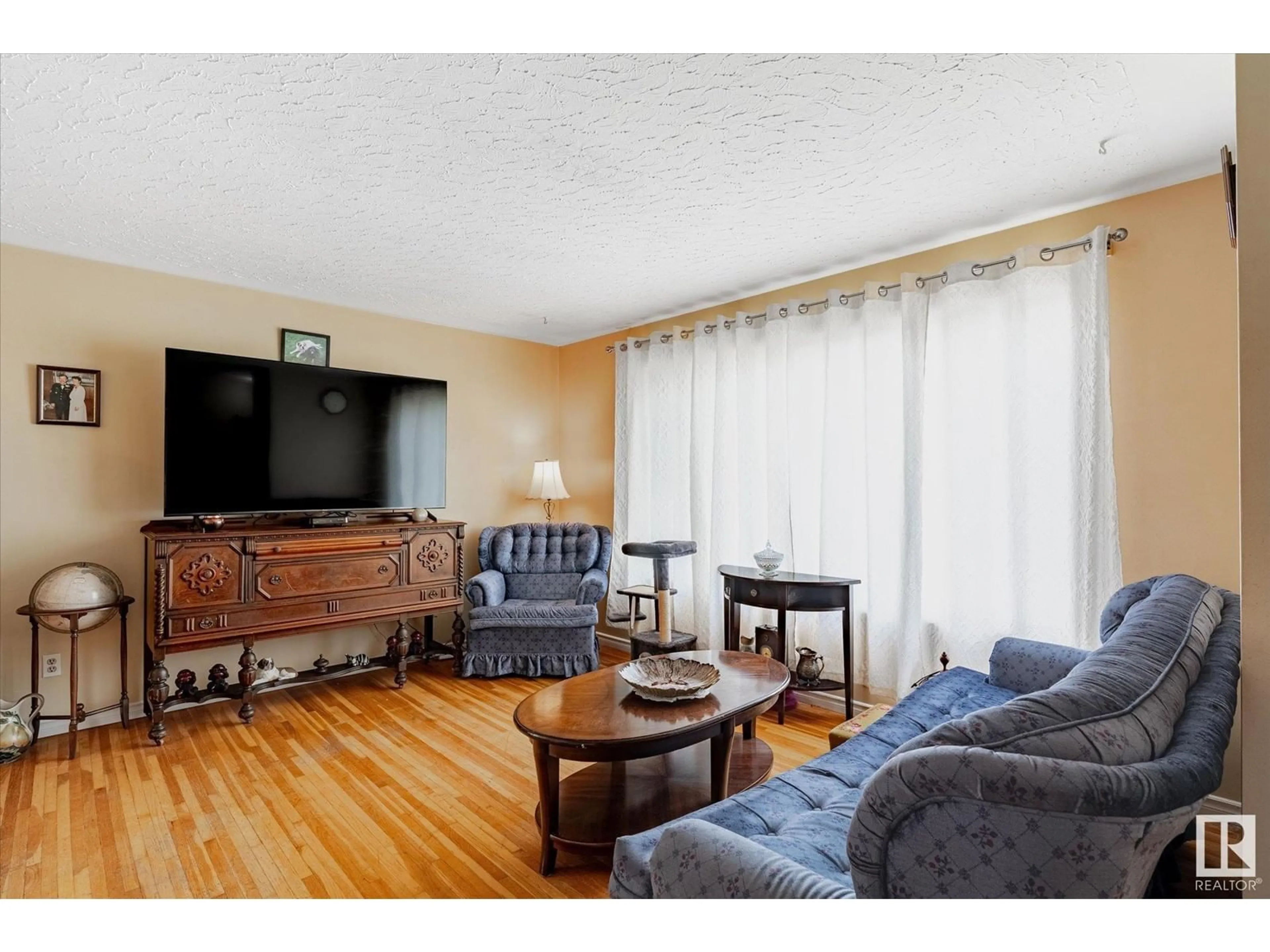 Living room with furniture, wood/laminate floor for 10403 137 AV, Edmonton Alberta T6E1Y9