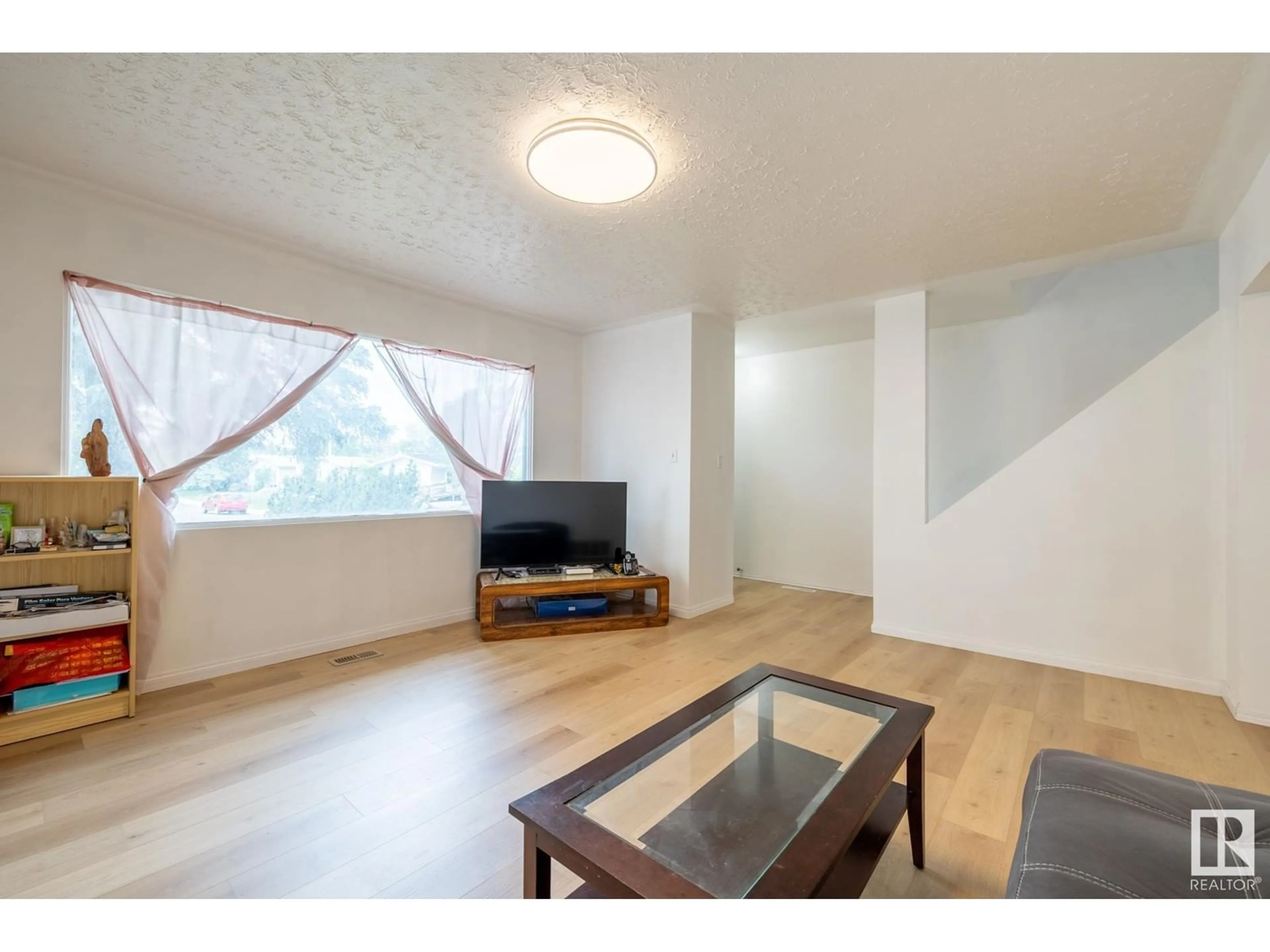 Living room with furniture, wood/laminate floor for 10704 51 AV, Edmonton Alberta T6H0L2