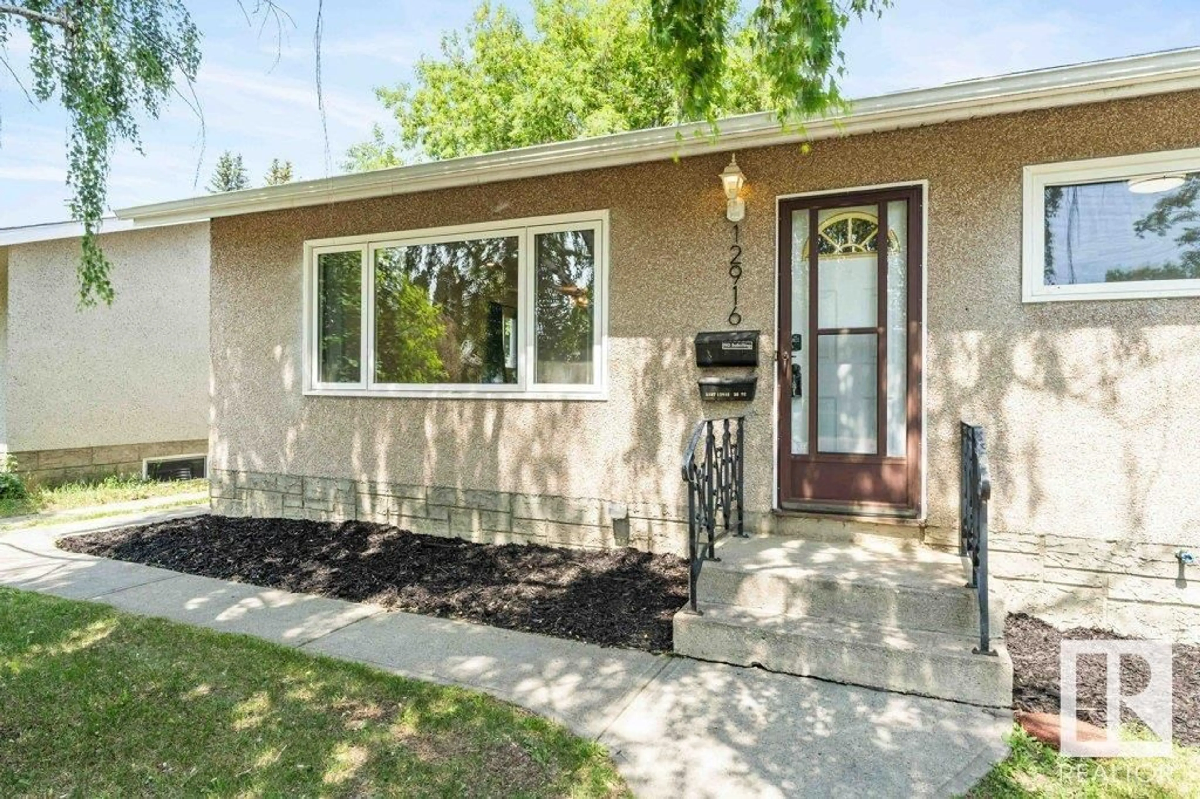 Home with vinyl exterior material, street for 12916 136 AV, Edmonton Alberta T5L4B1