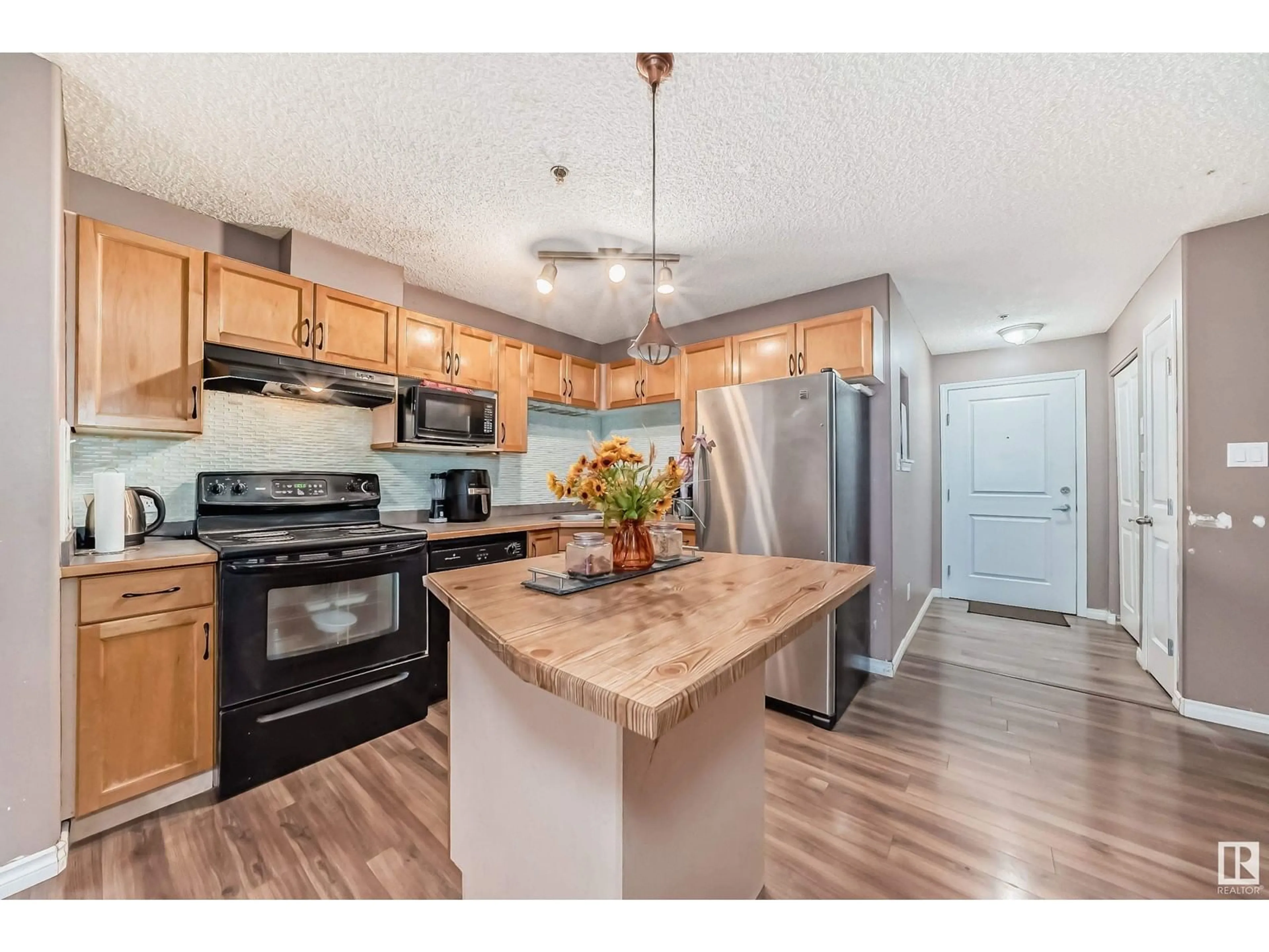 Open concept kitchen, wood/laminate floor for 110 - 2305 35A AV, Edmonton Alberta T6T1Z2