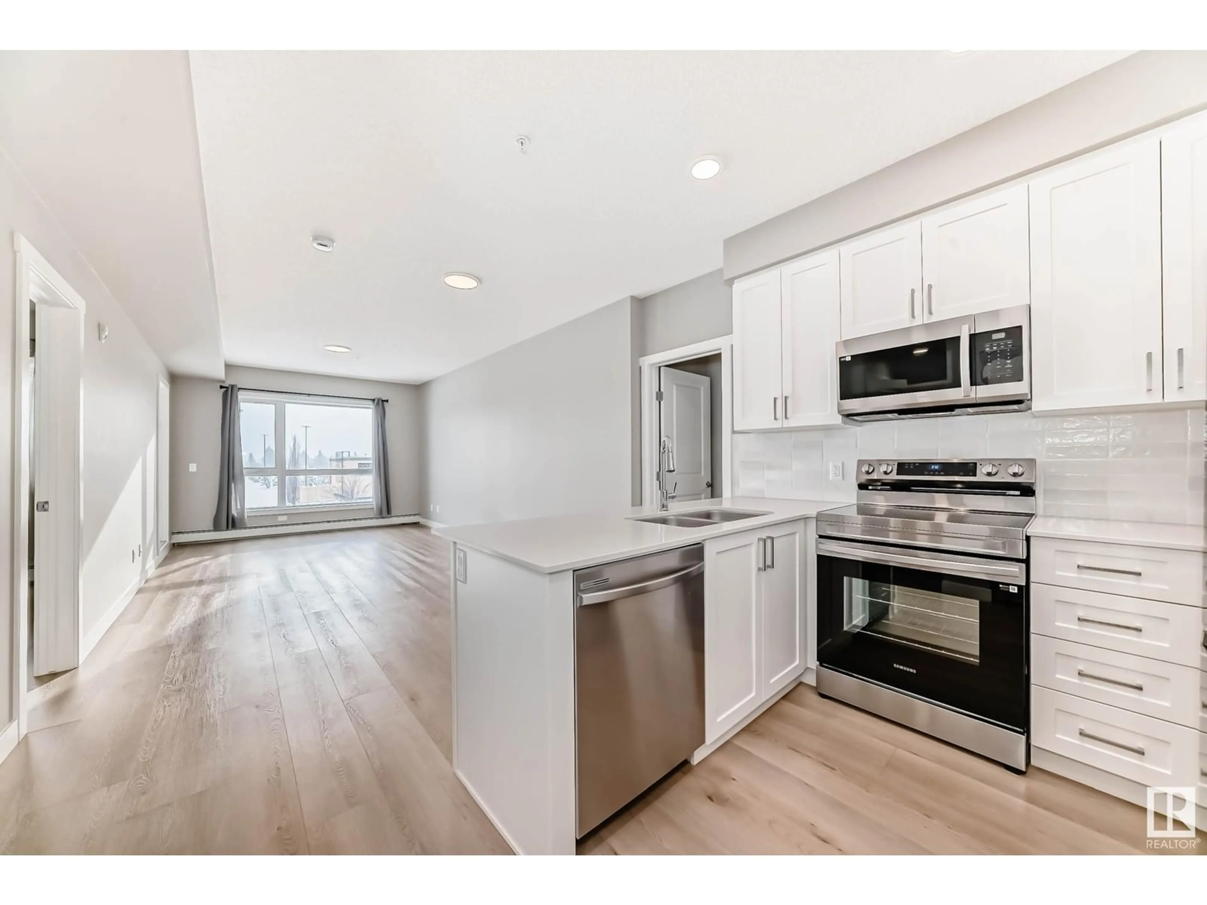 Open concept kitchen, wood/laminate floor for #221 - 12804 140 AV, Edmonton Alberta T6V1K4