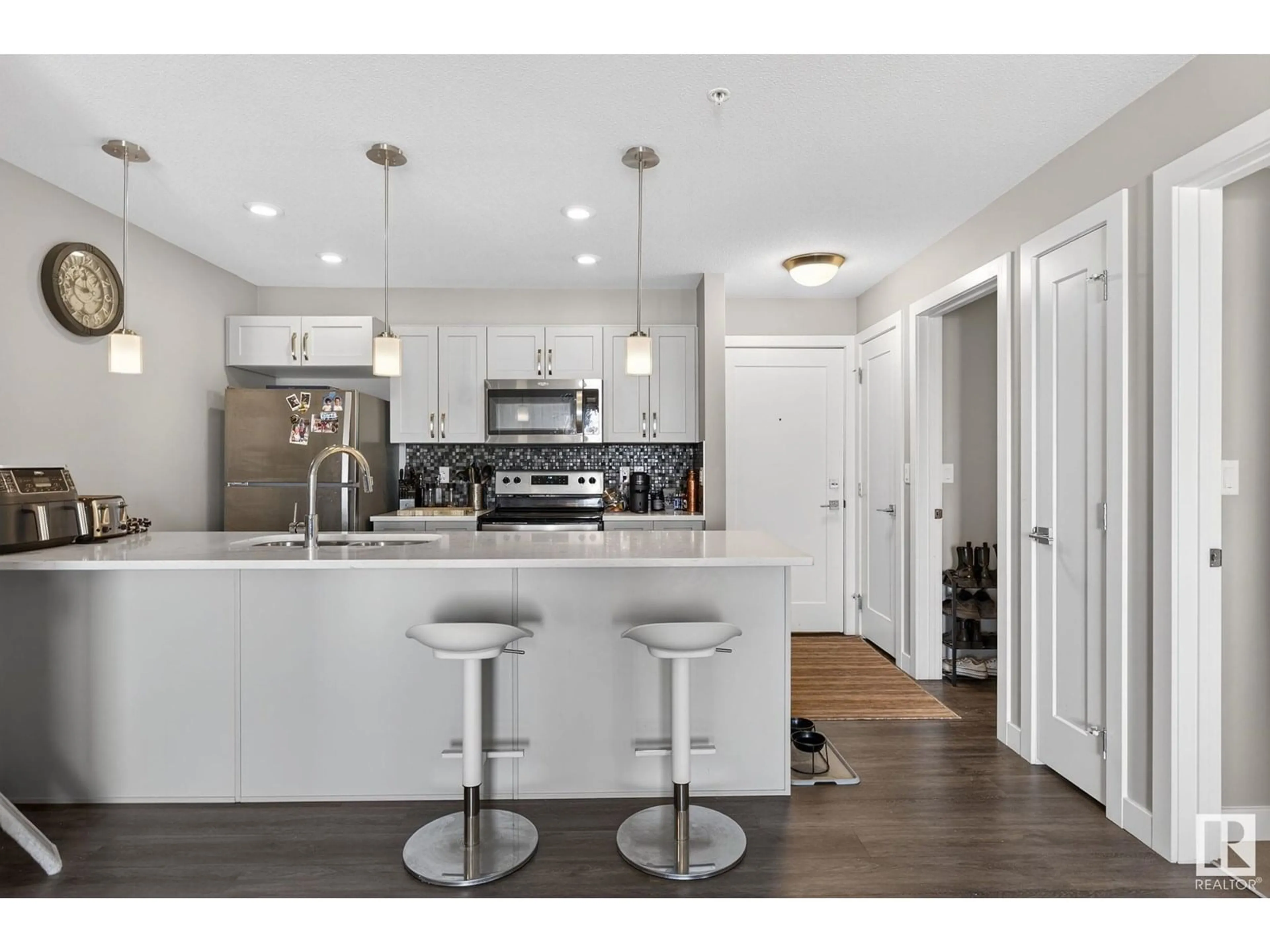 Open concept kitchen, wood/laminate floor for #306 - 1027 173 ST, Edmonton Alberta T6W2E4