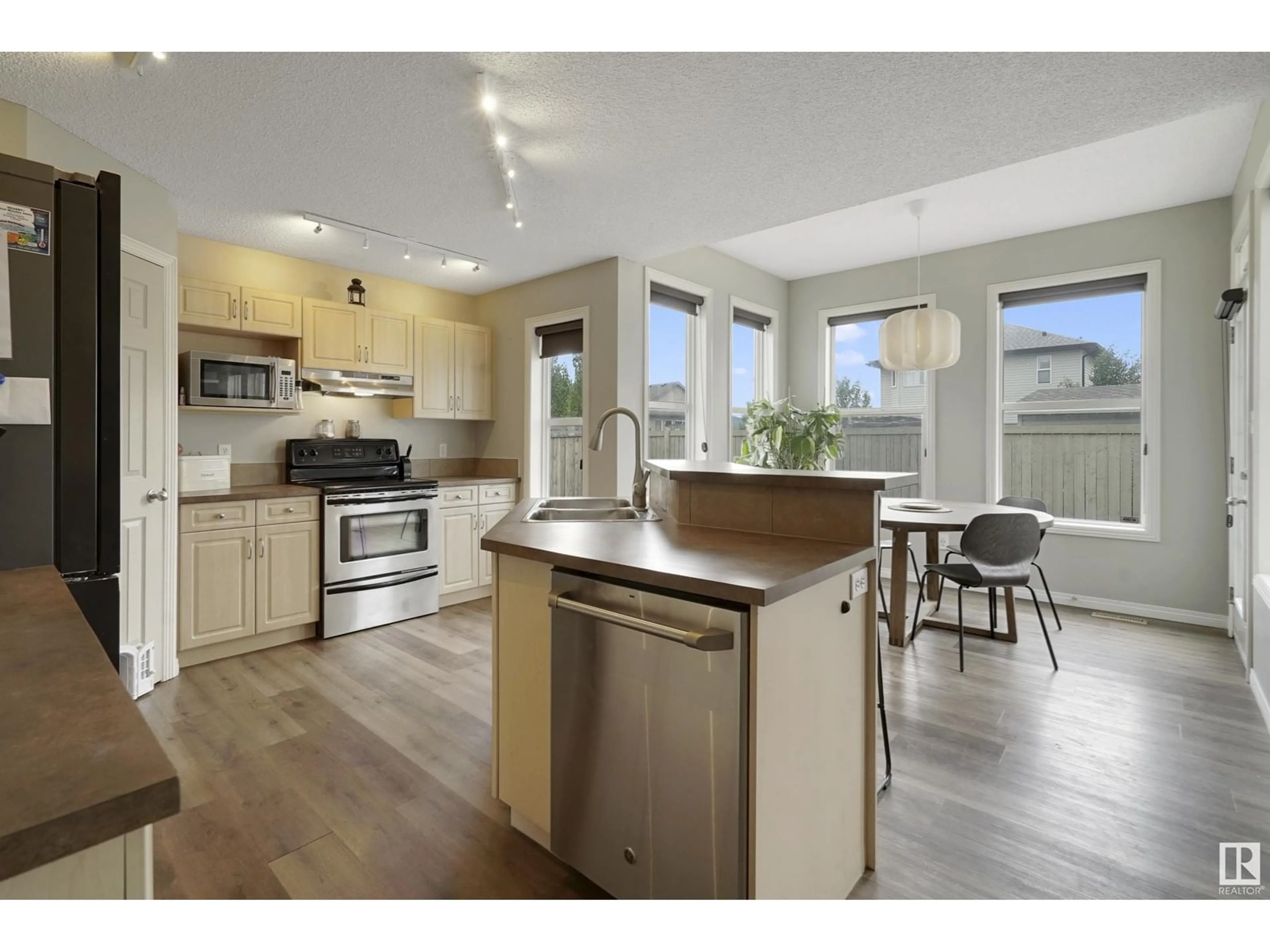 Open concept kitchen, wood/laminate floor for 8782 5 AV SW, Edmonton Alberta T6X1E2