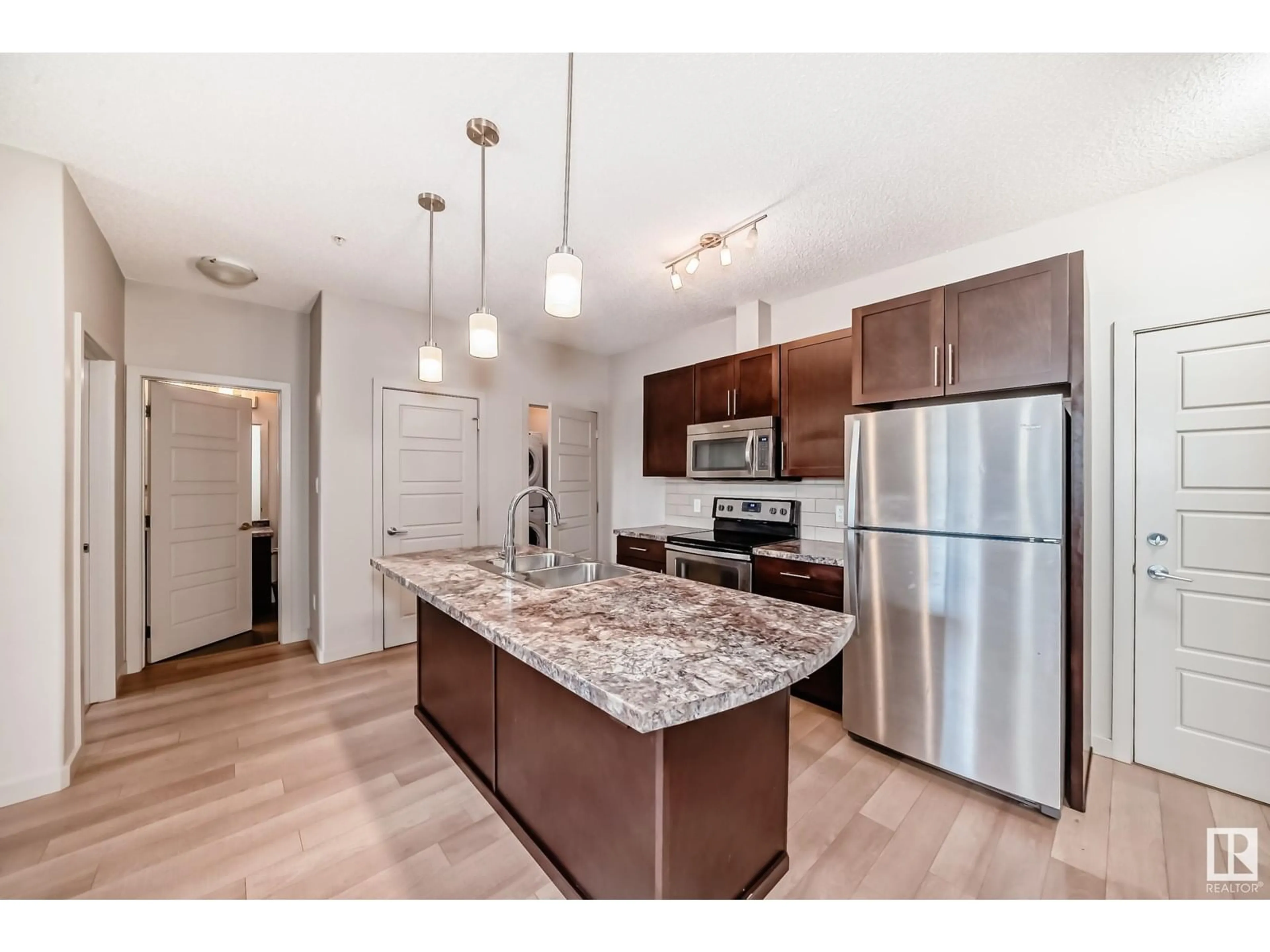 Open concept kitchen, wood/laminate floor for #106 - 1004 ROSENTHAL BV, Edmonton Alberta T5T7C6