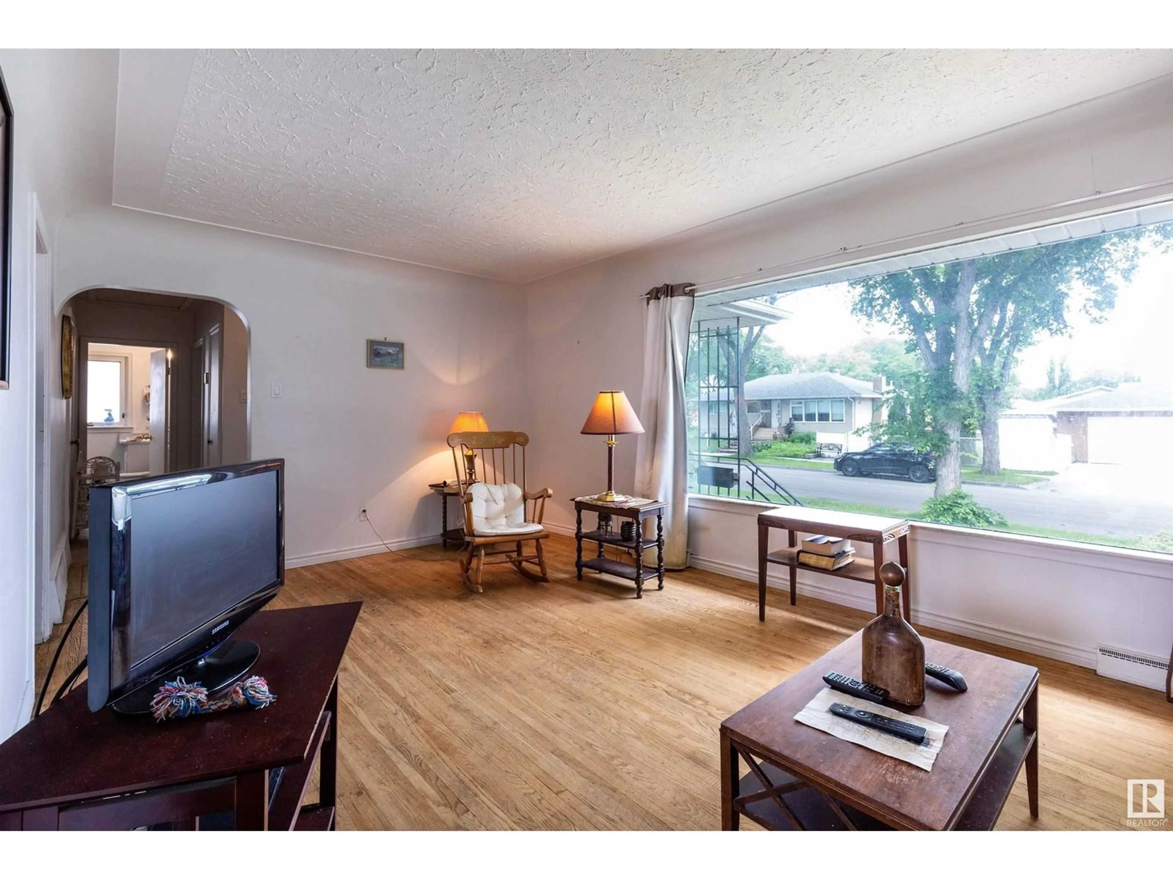 Living room with furniture, wood/laminate floor for 13307 116 AV, Edmonton Alberta T5M3E4