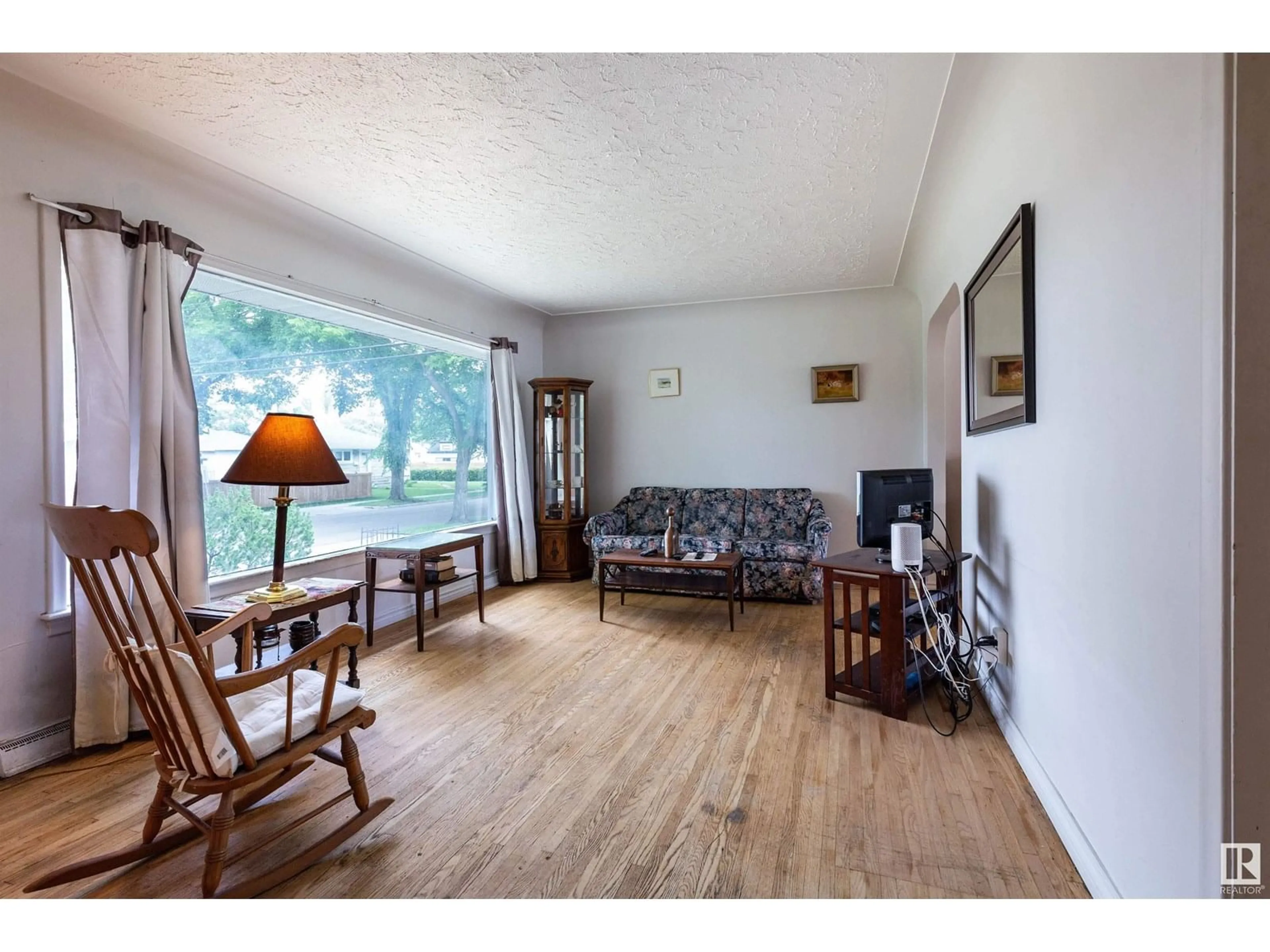 Living room with furniture, wood/laminate floor for 13307 116 AV, Edmonton Alberta T5M3E4