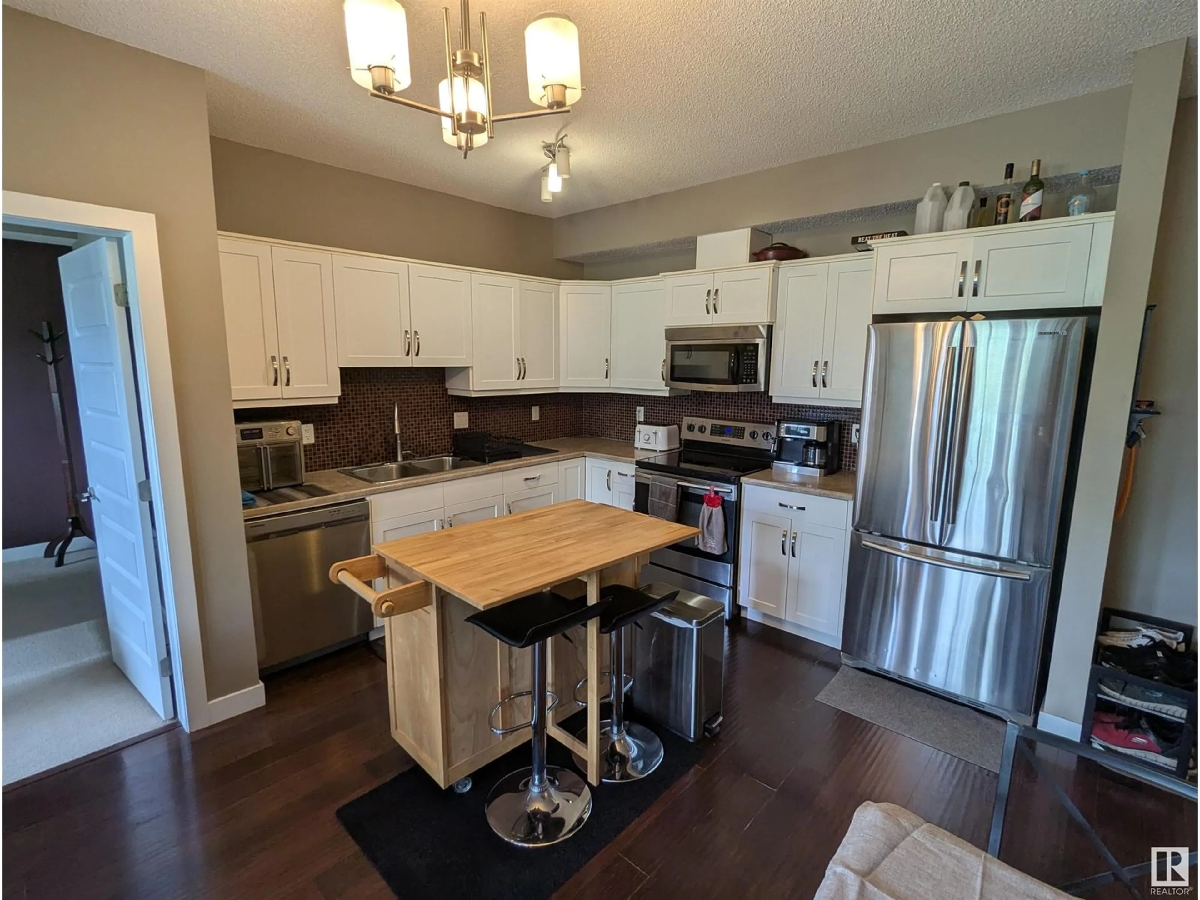 Open concept kitchen, wood/laminate floor for #319 - 8730 82 AV, Edmonton Alberta T6C0Z1