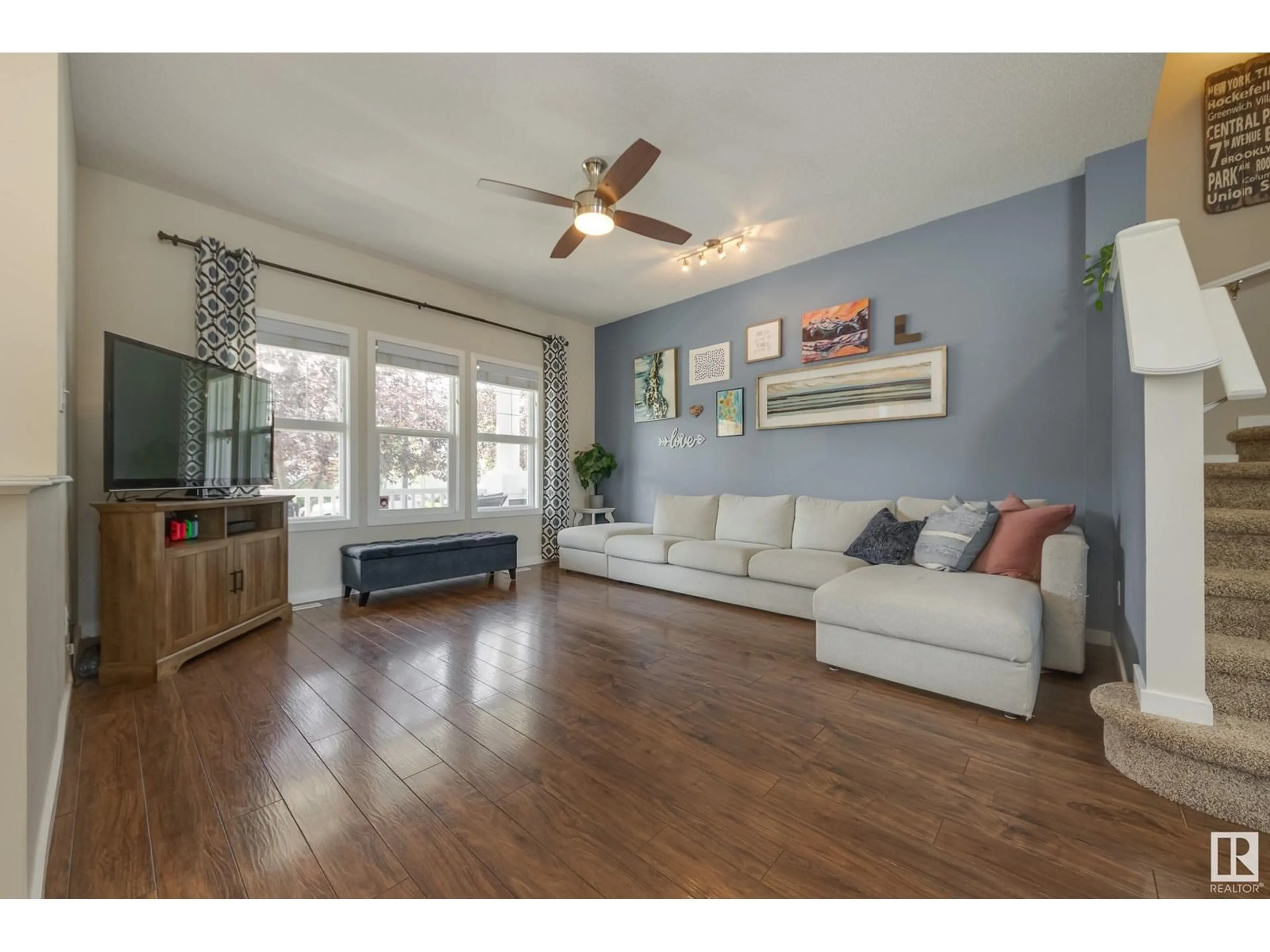 Living room with furniture, wood/laminate floor for 7404 15A AV SW, Edmonton Alberta T6X0E1