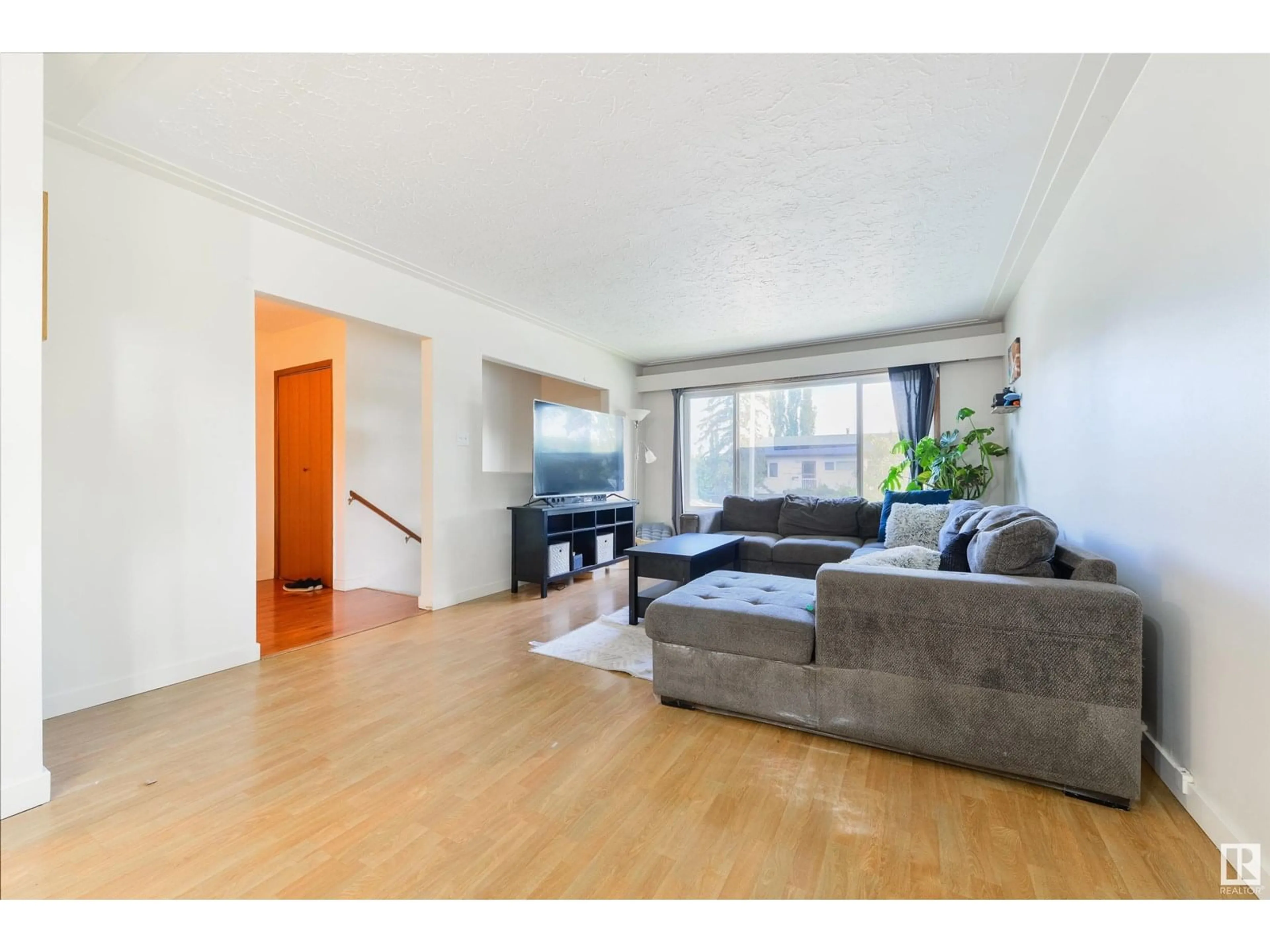 Living room with furniture, wood/laminate floor for NW - 12403 130 AV, Edmonton Alberta T5L3K9