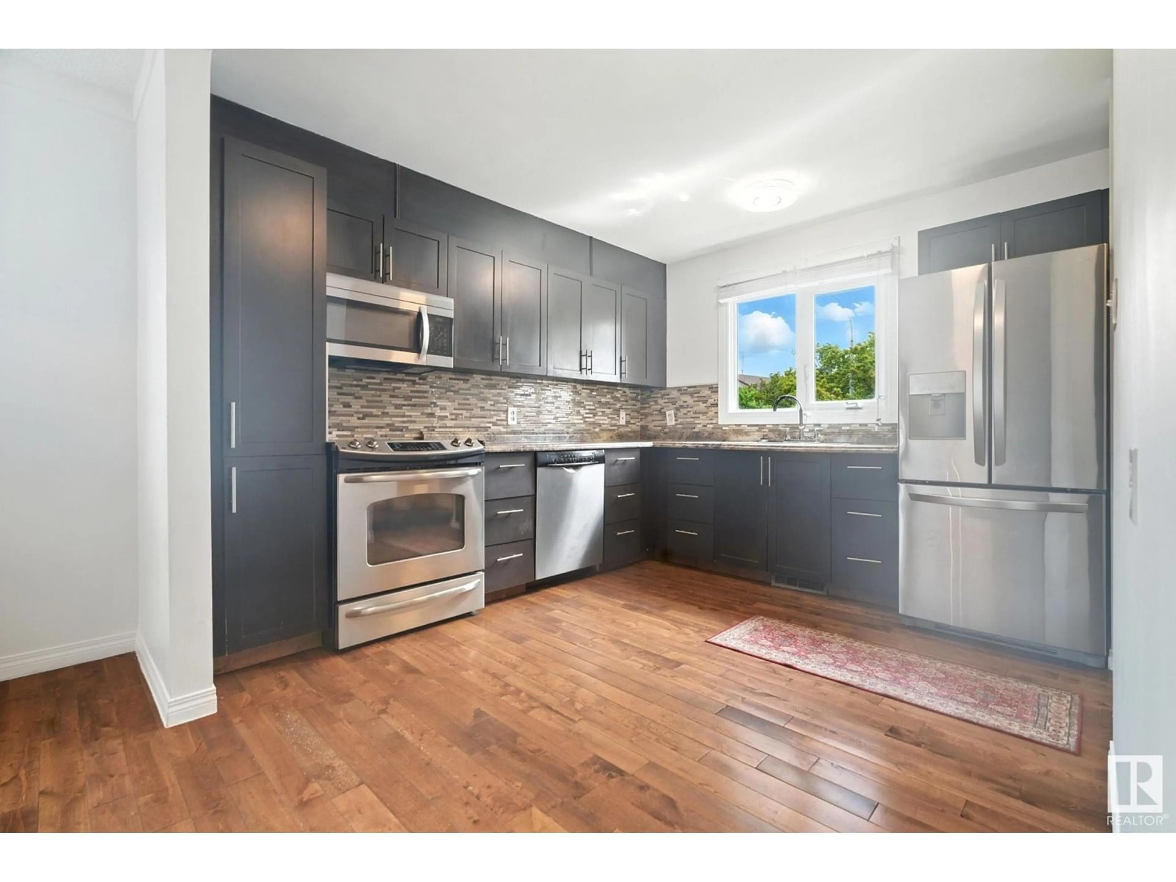 Open concept kitchen, wood/laminate floor for NW - 9541 A 180 ST, Edmonton Alberta T5T2Z4