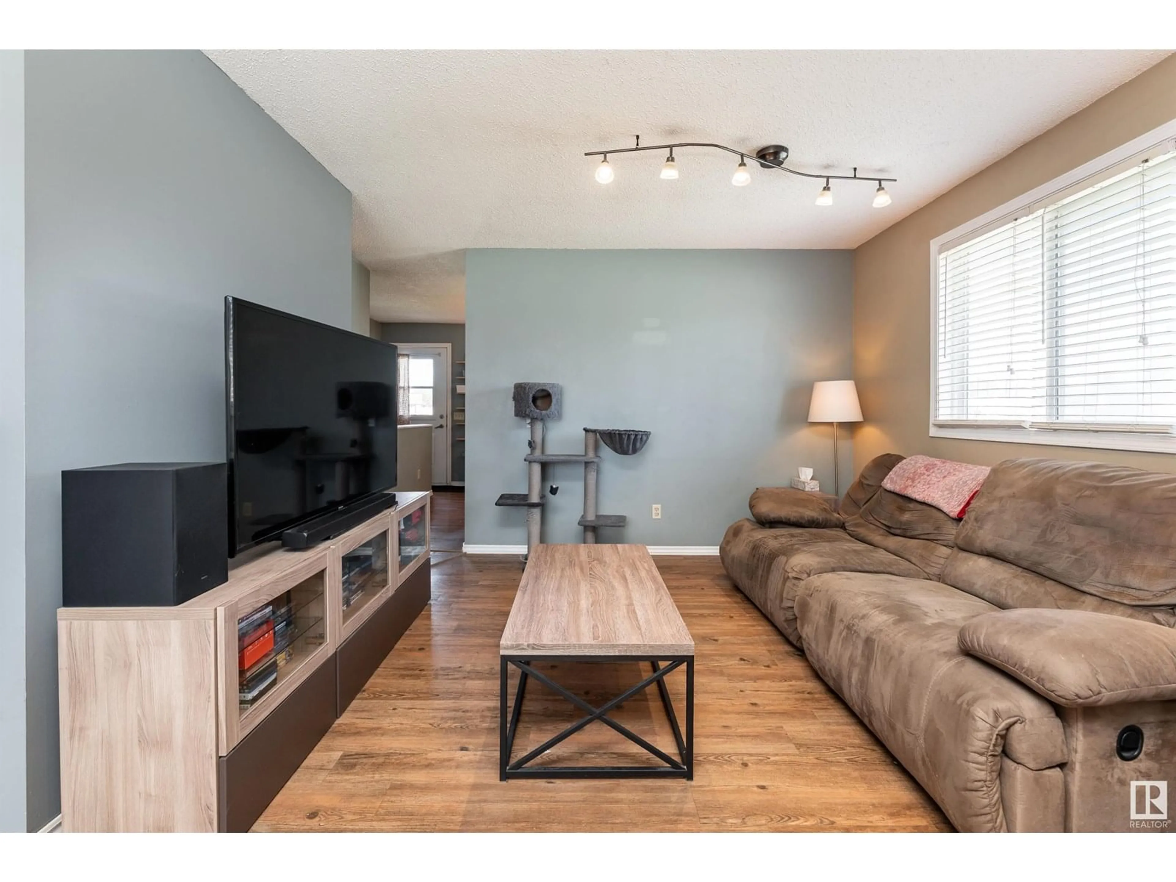 Living room with furniture, wood/laminate floor for 118 - 8930 99 AV, Fort Saskatchewan Alberta T8L3L1