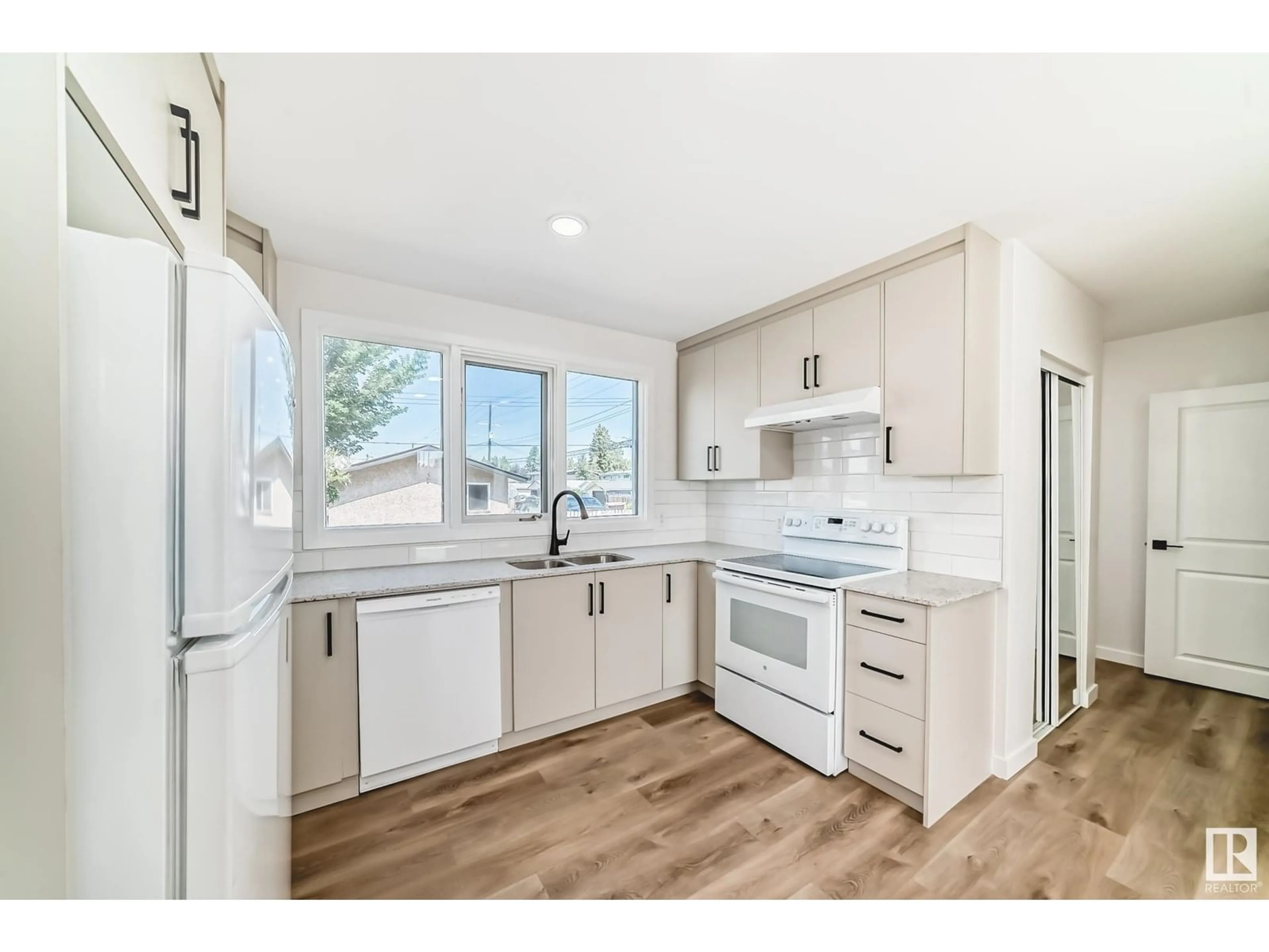 Open concept kitchen, wood/laminate floor for NW - 10820 132 AV, Edmonton Alberta T5E0Z6