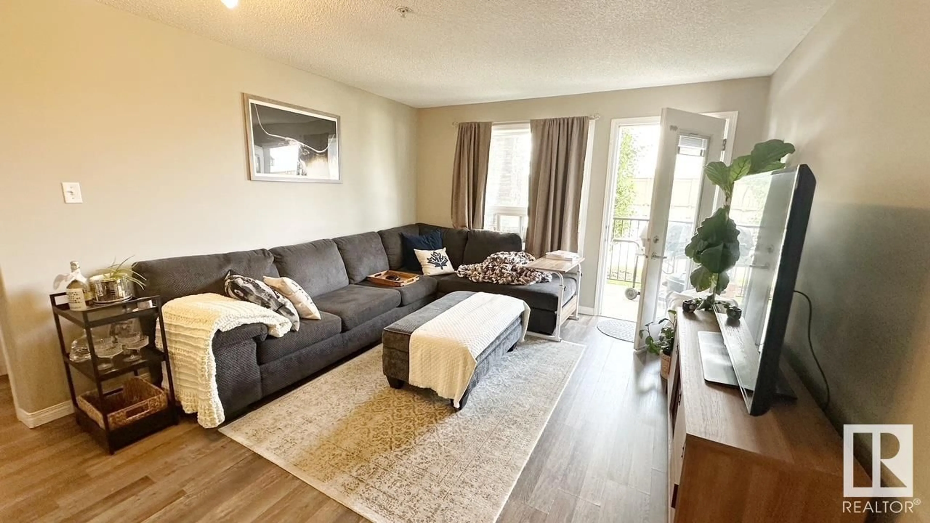 Living room with furniture, wood/laminate floor for 9363 - 1112 SIMPSON DR, Edmonton Alberta T6R0N2