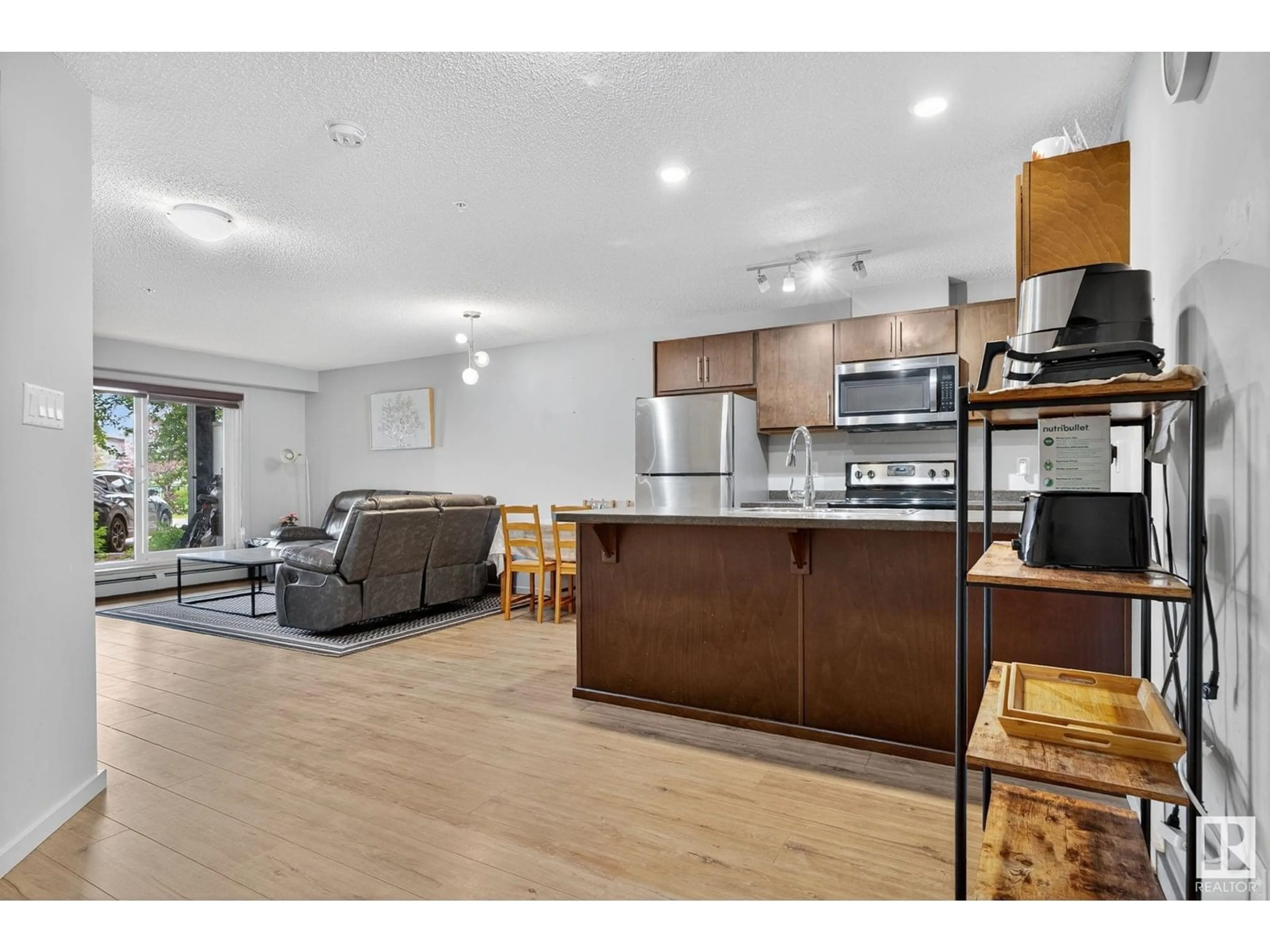 Open concept kitchen, wood/laminate floor for #110 - 5404 7 AV, Edmonton Alberta T6K2K4
