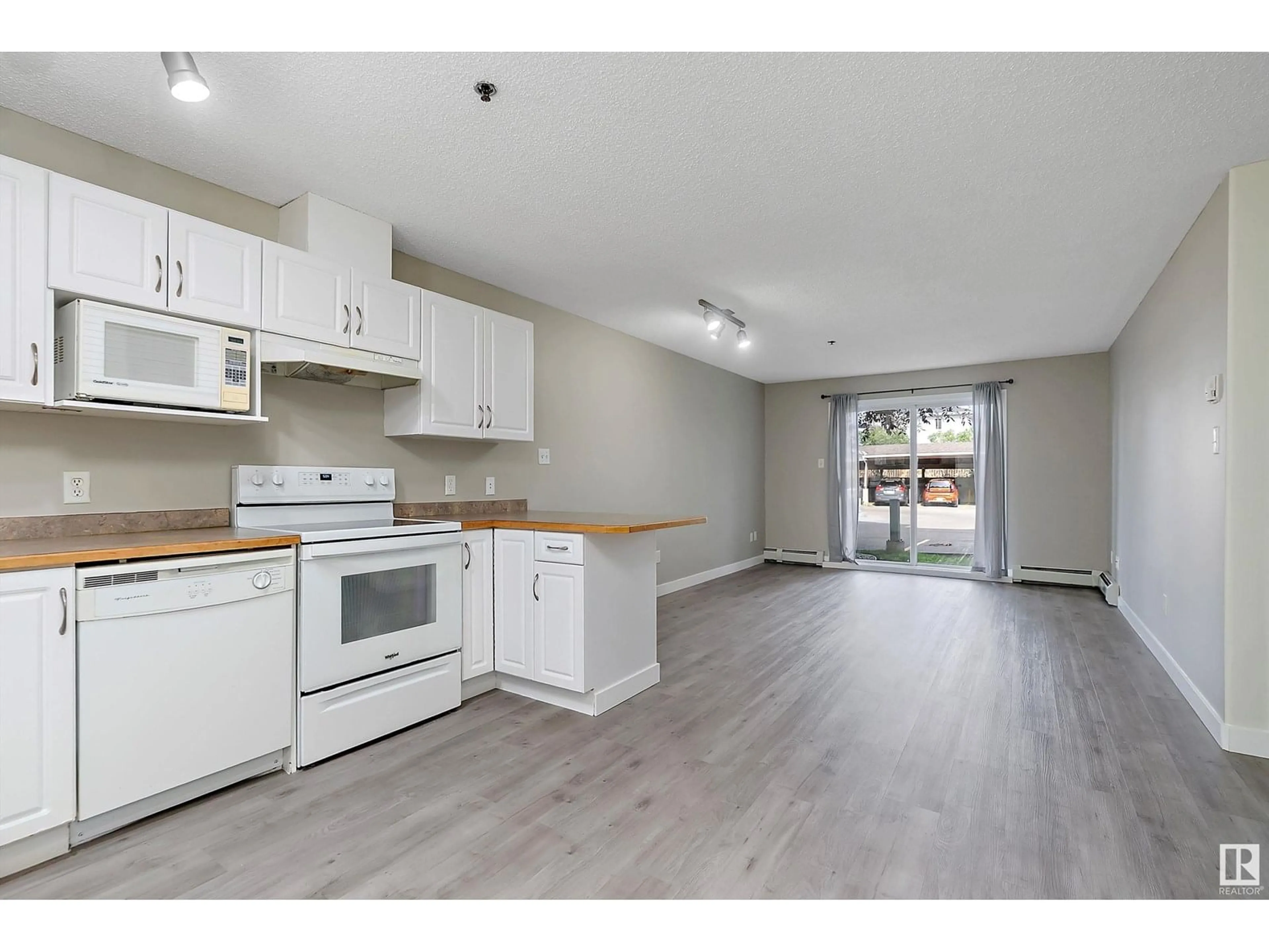 Open concept kitchen, wood/laminate floor for #123 - 2305 35A AV, Edmonton Alberta T6T1Z2