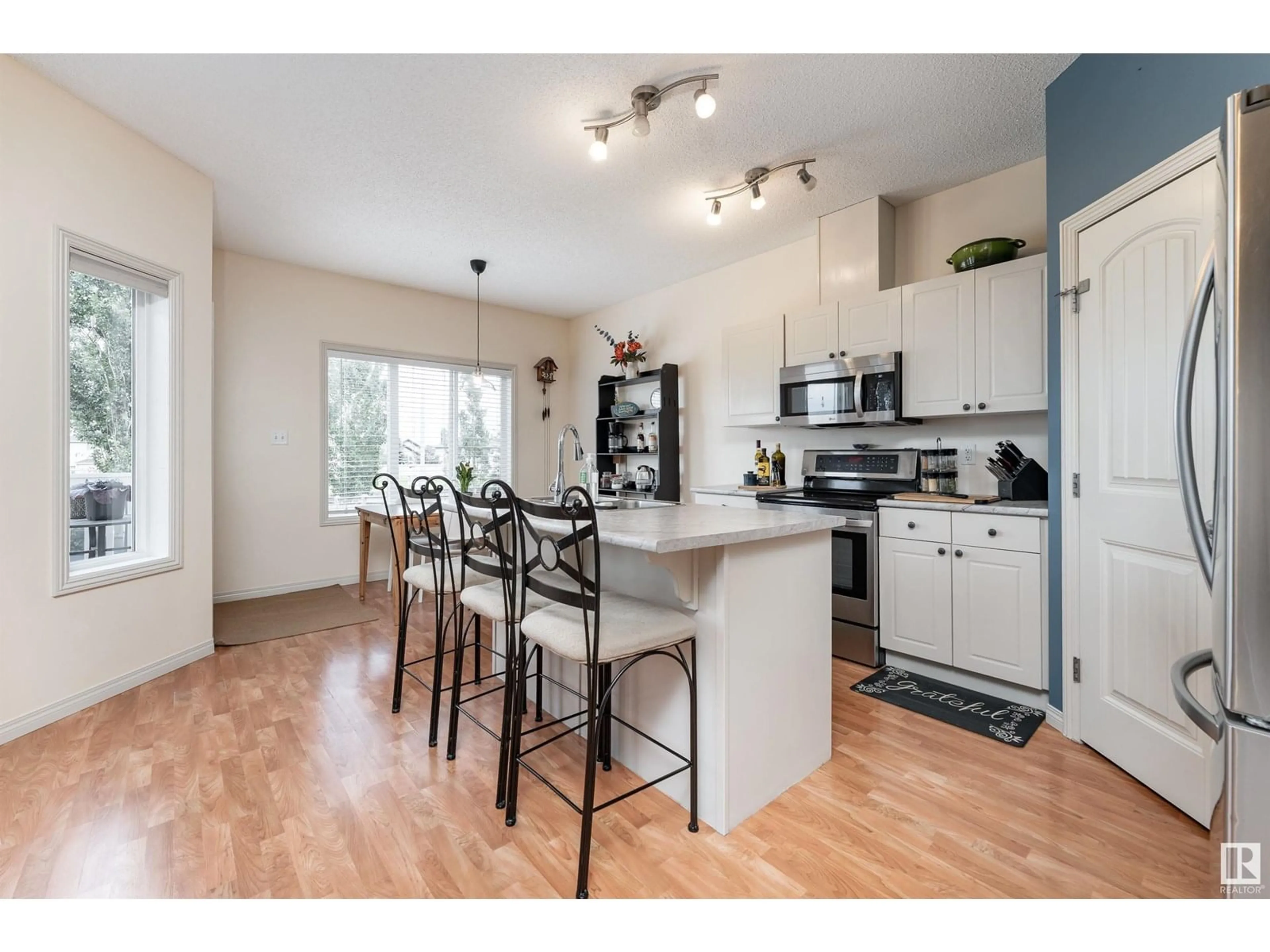 Open concept kitchen, wood/laminate floor for SW - 11724 10 AV, Edmonton Alberta T6W0B7