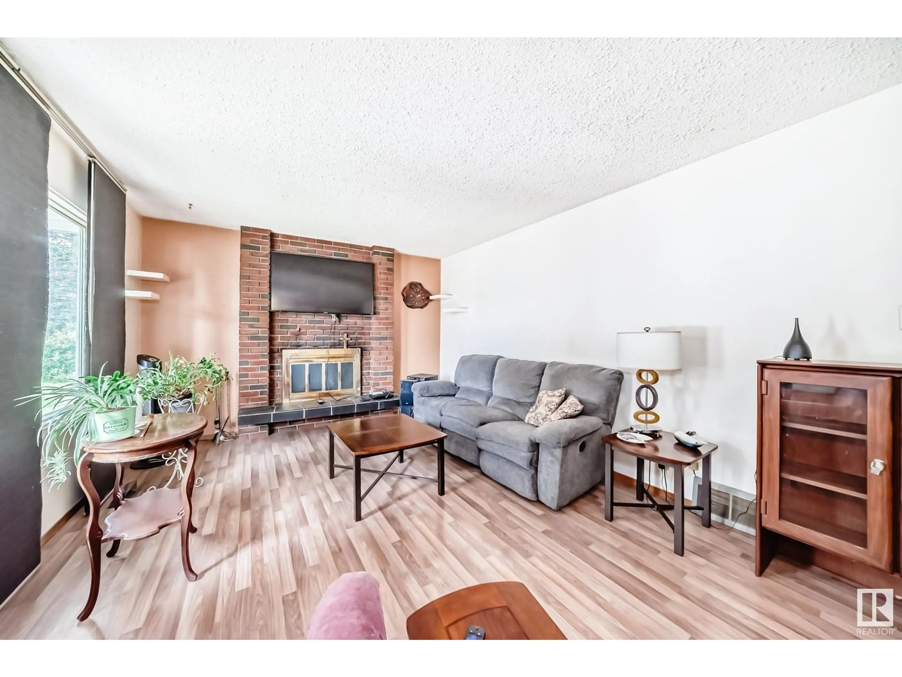 Living room with furniture, wood/laminate floor for 7820 22 ST, Edmonton Alberta T6K2E3