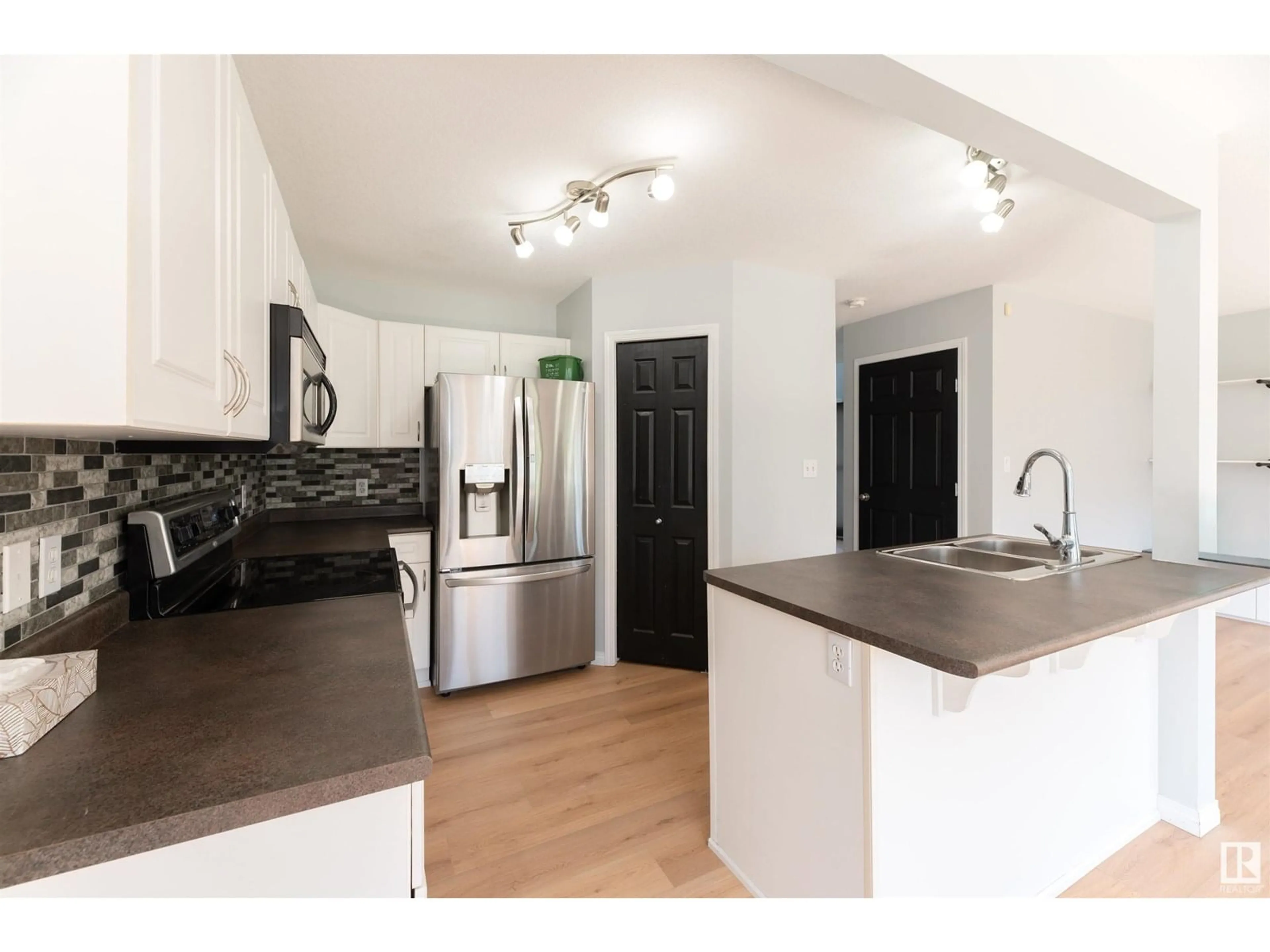 Open concept kitchen, wood/laminate floor for 3729 138A AV, Edmonton Alberta T5Y3G6