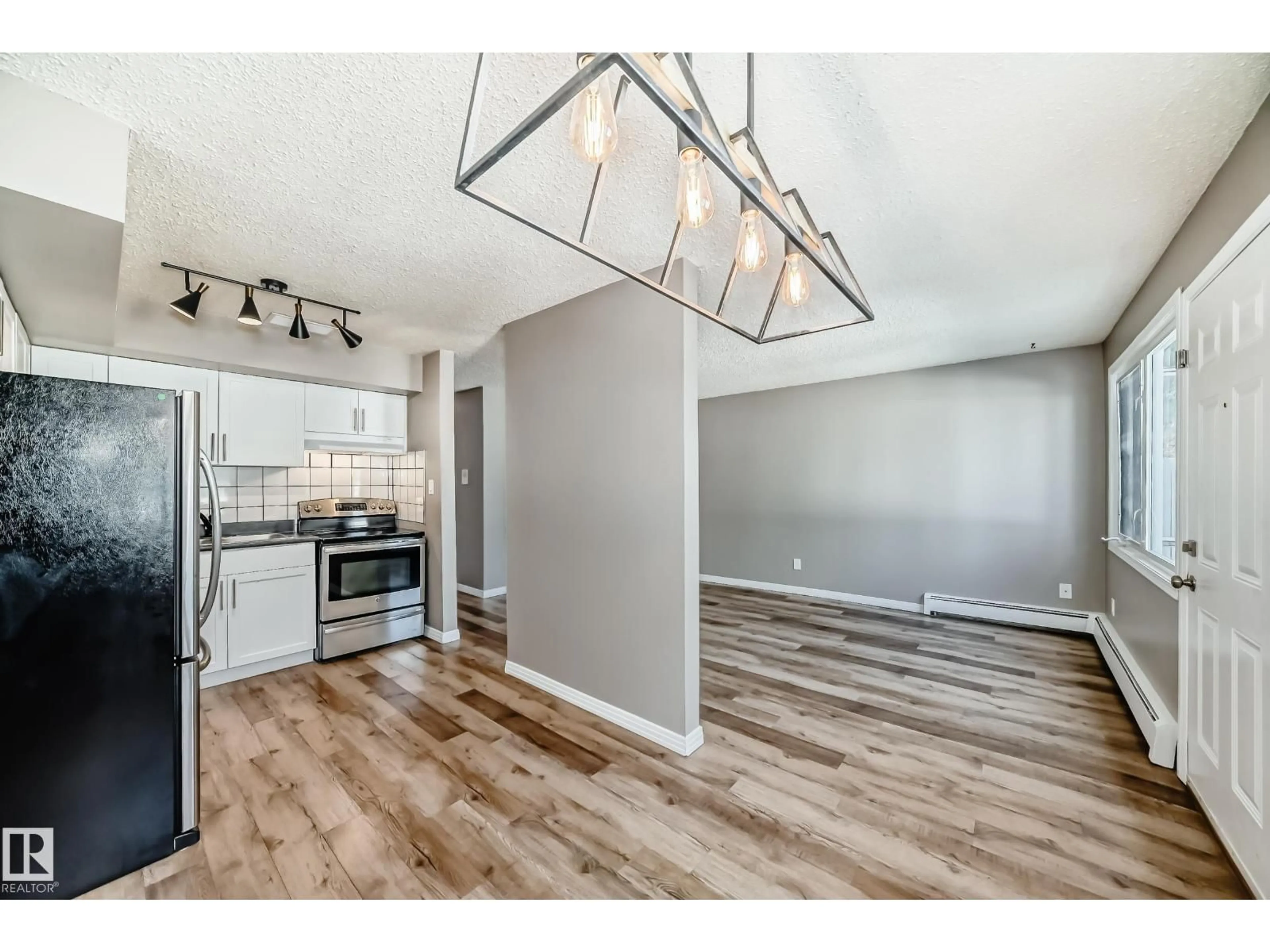 Open concept kitchen, wood/laminate floor for #112 - 16340 109 ST, Edmonton Alberta T5X2T4