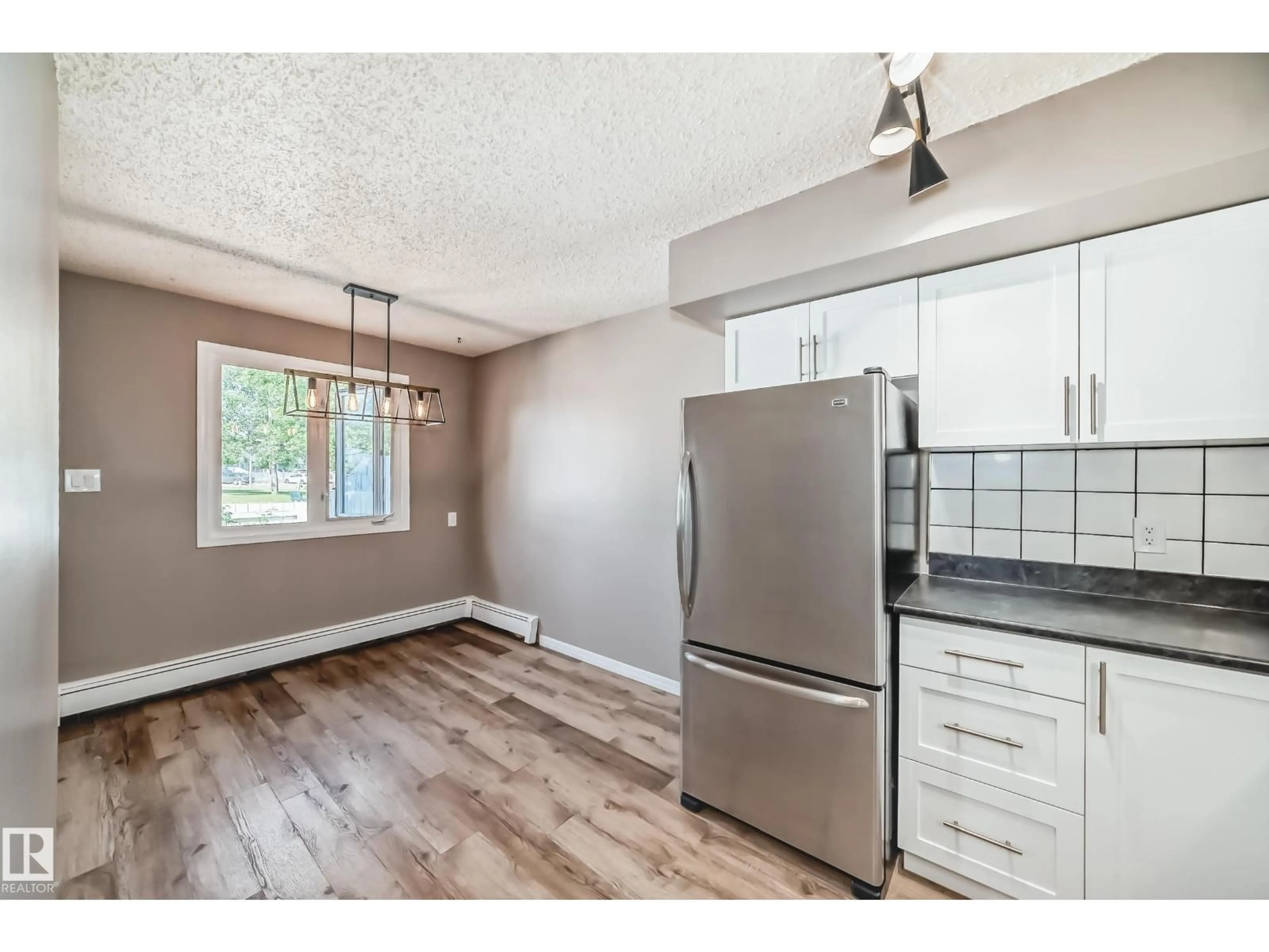 Open concept kitchen, wood/laminate floor for #112 - 16340 109 ST, Edmonton Alberta T5X2T4