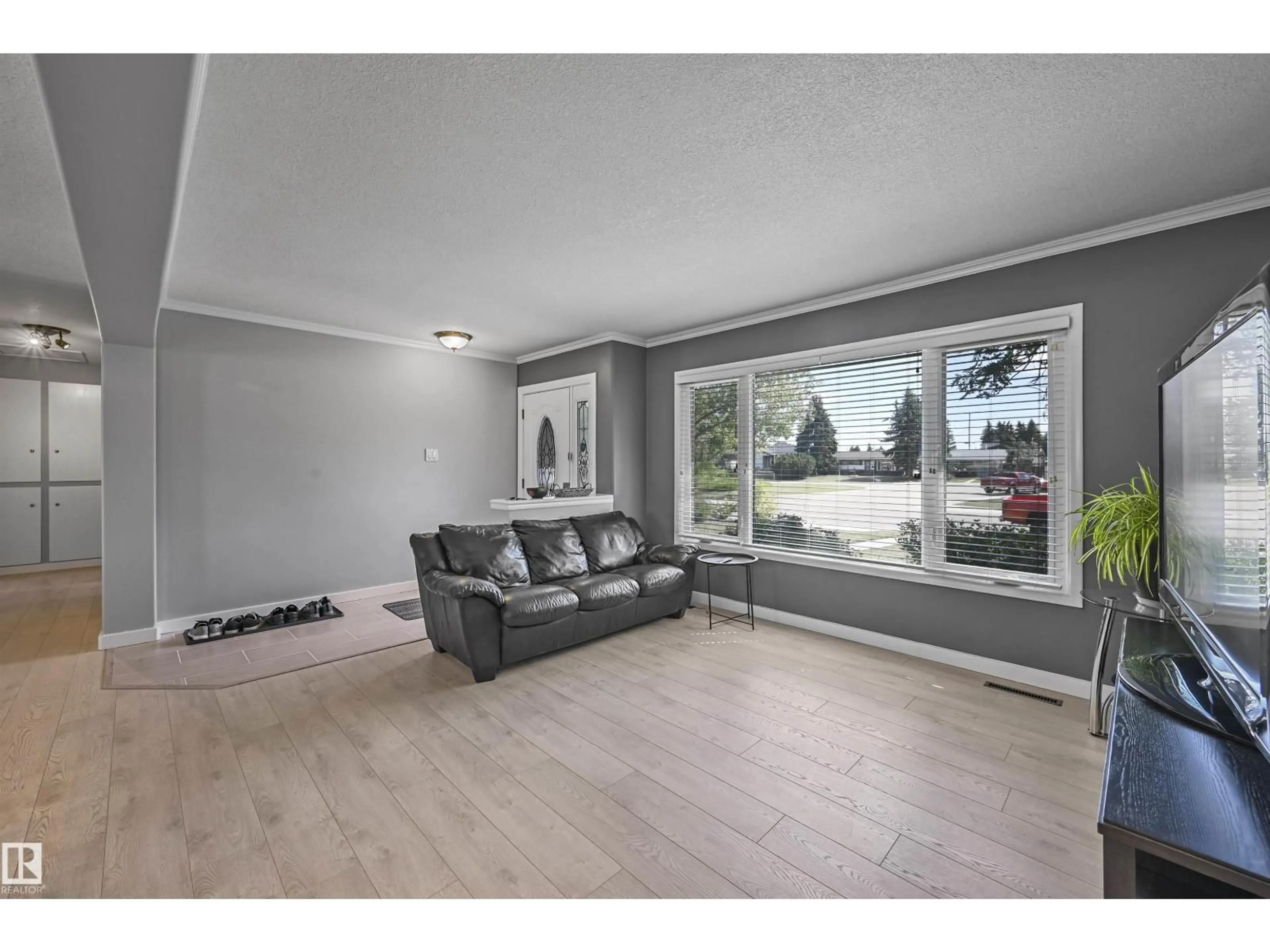 Living room with furniture, wood/laminate floor for 10704 136 AV, Edmonton Alberta T5E1W4