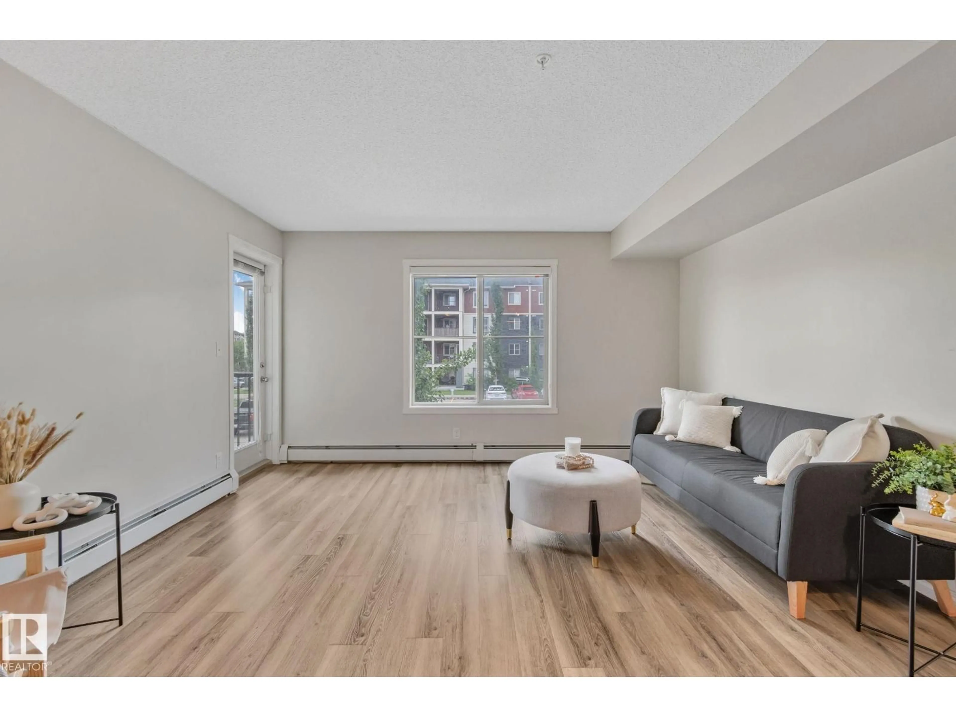 Living room with furniture, wood/laminate floor for 5804 - 210 MULLEN PL, Edmonton Alberta T6R0W3