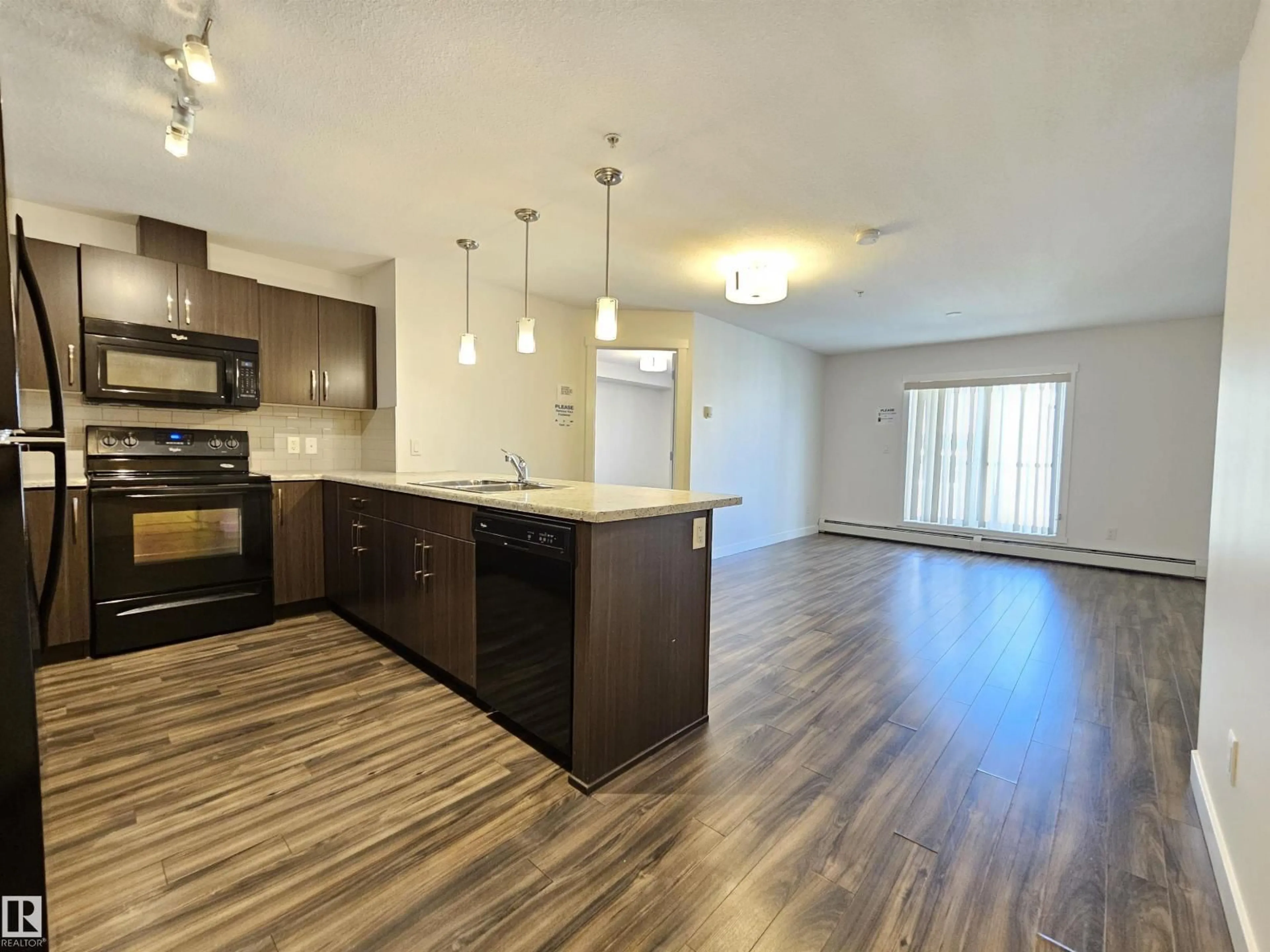 Open concept kitchen, wood/laminate floor for #205 - 3670 139 AV, Edmonton Alberta T5Y3N5