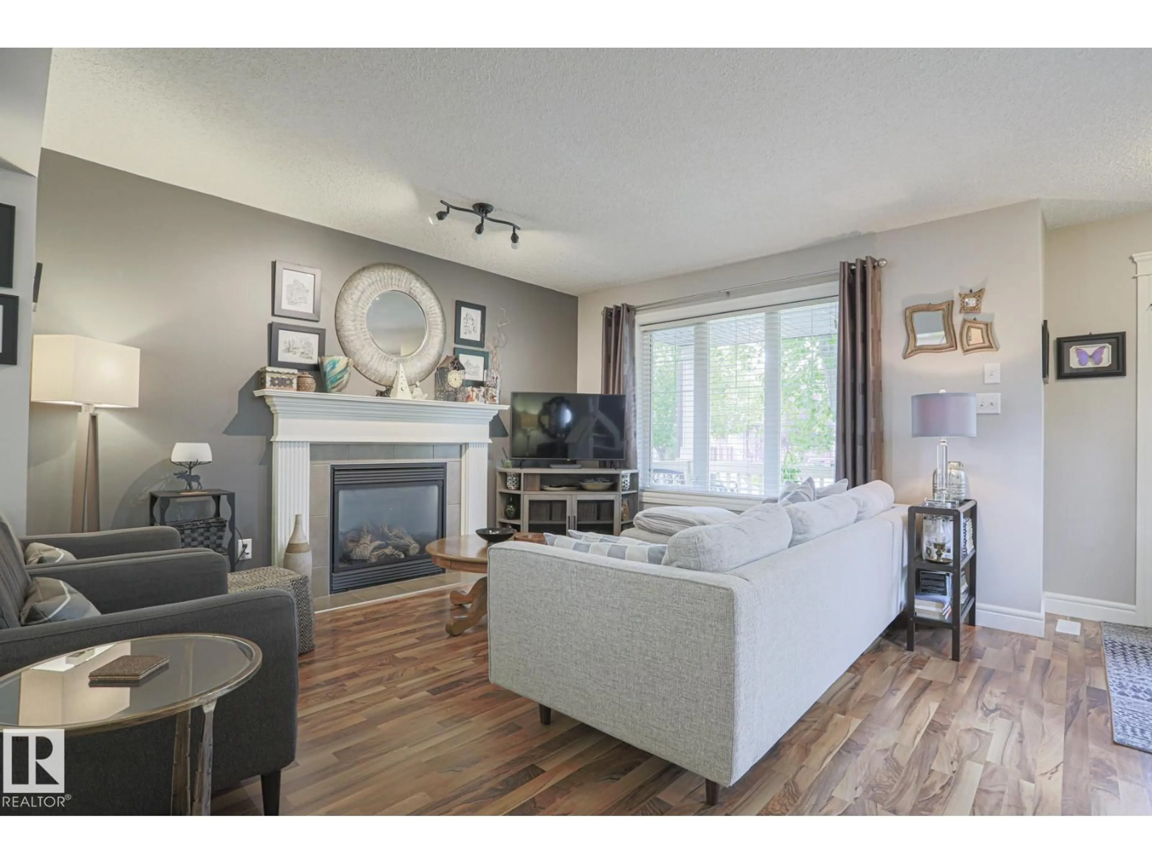 Living room with furniture, wood/laminate floor for 12039 18 AV, Edmonton Alberta T6W1W3