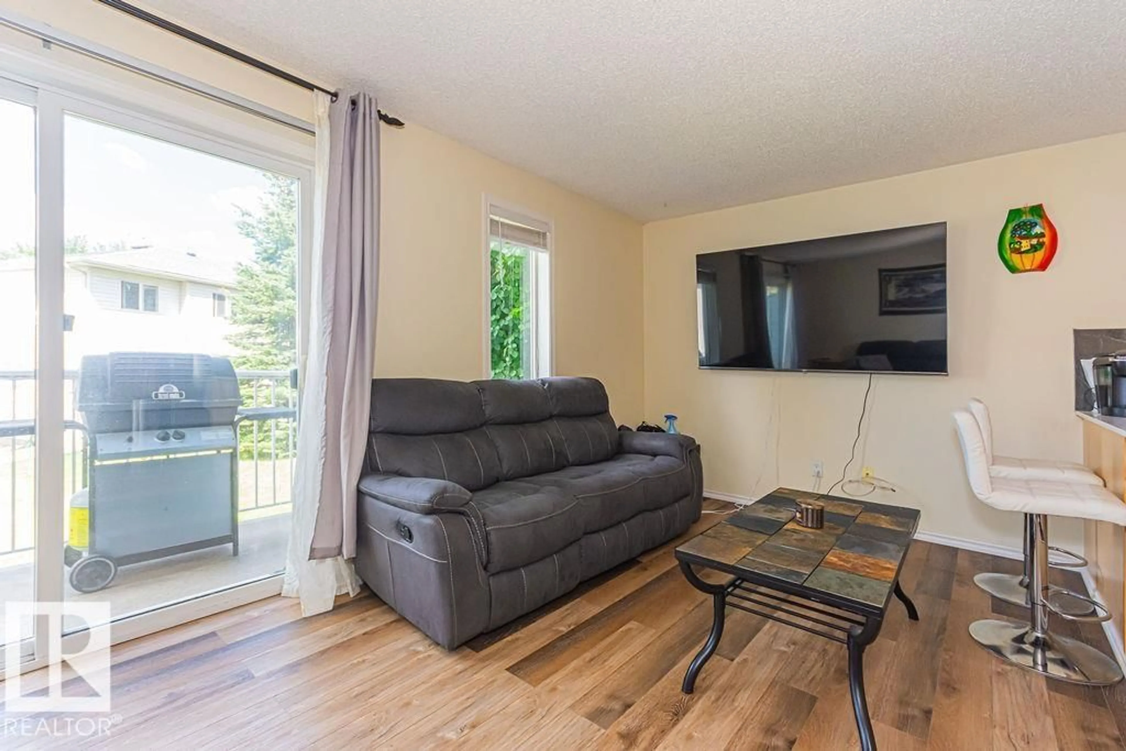 Living room with furniture, wood/laminate floor for 451 - 56 HYNDMAN CR, Edmonton Alberta T5A5J3