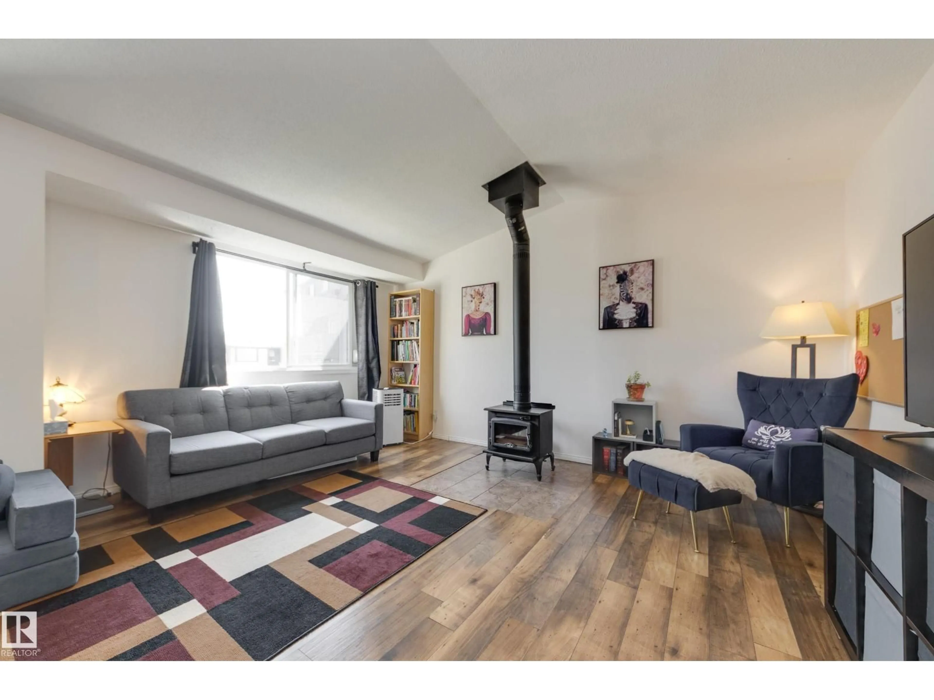 Living room with furniture, wood/laminate floor for NW - 1522 69 ST, Edmonton Alberta T6K3R3
