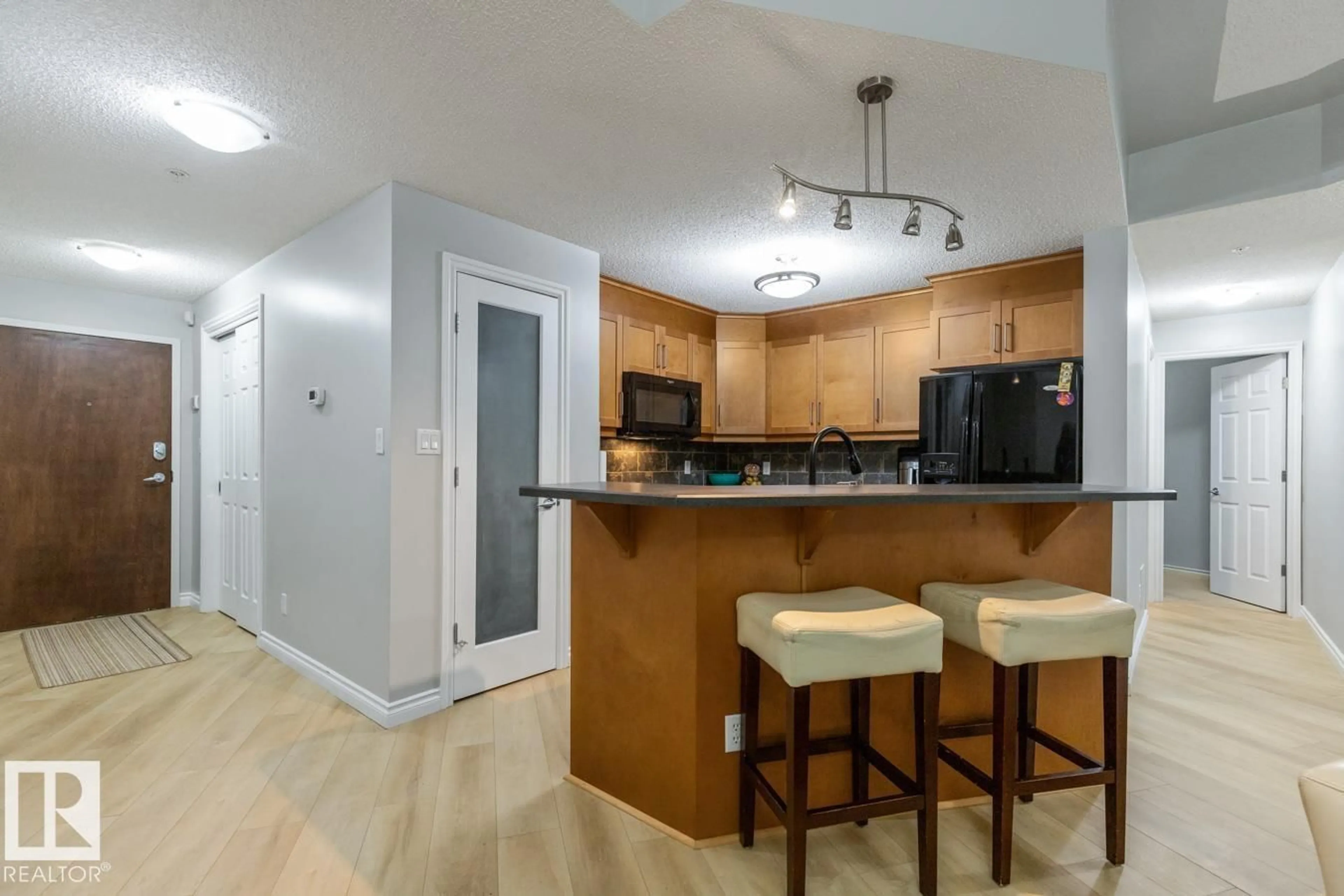 Open concept kitchen, wood/laminate floor for #402 - 9020 JASPER AV, Edmonton Alberta T5H3S8