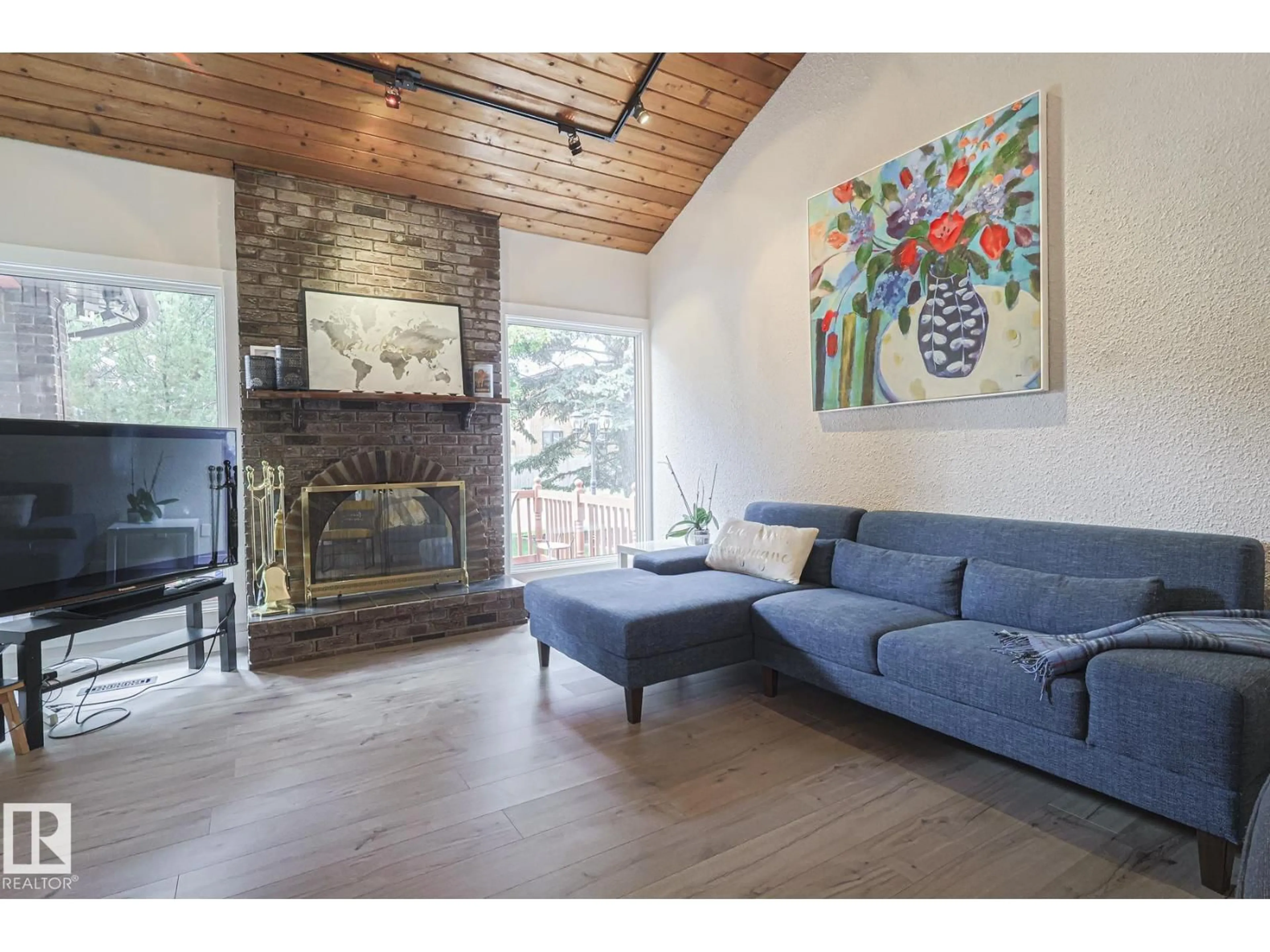 Living room with furniture, wood/laminate floor for 10614 25A AV, Edmonton Alberta T6J4K3
