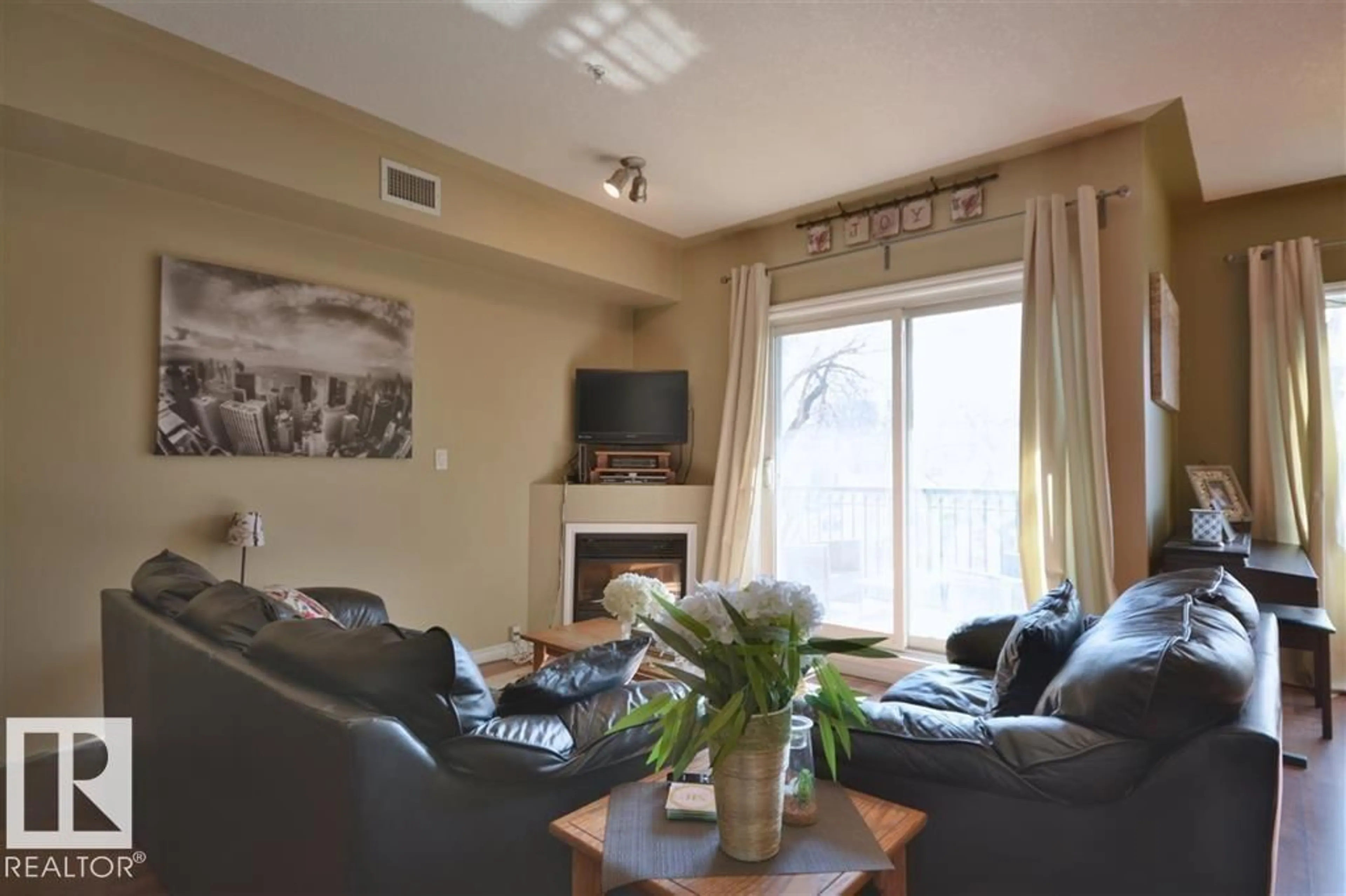 Living room with furniture, wood/laminate floor for 310 - 10606 102 AV, Edmonton Alberta T5J5E9